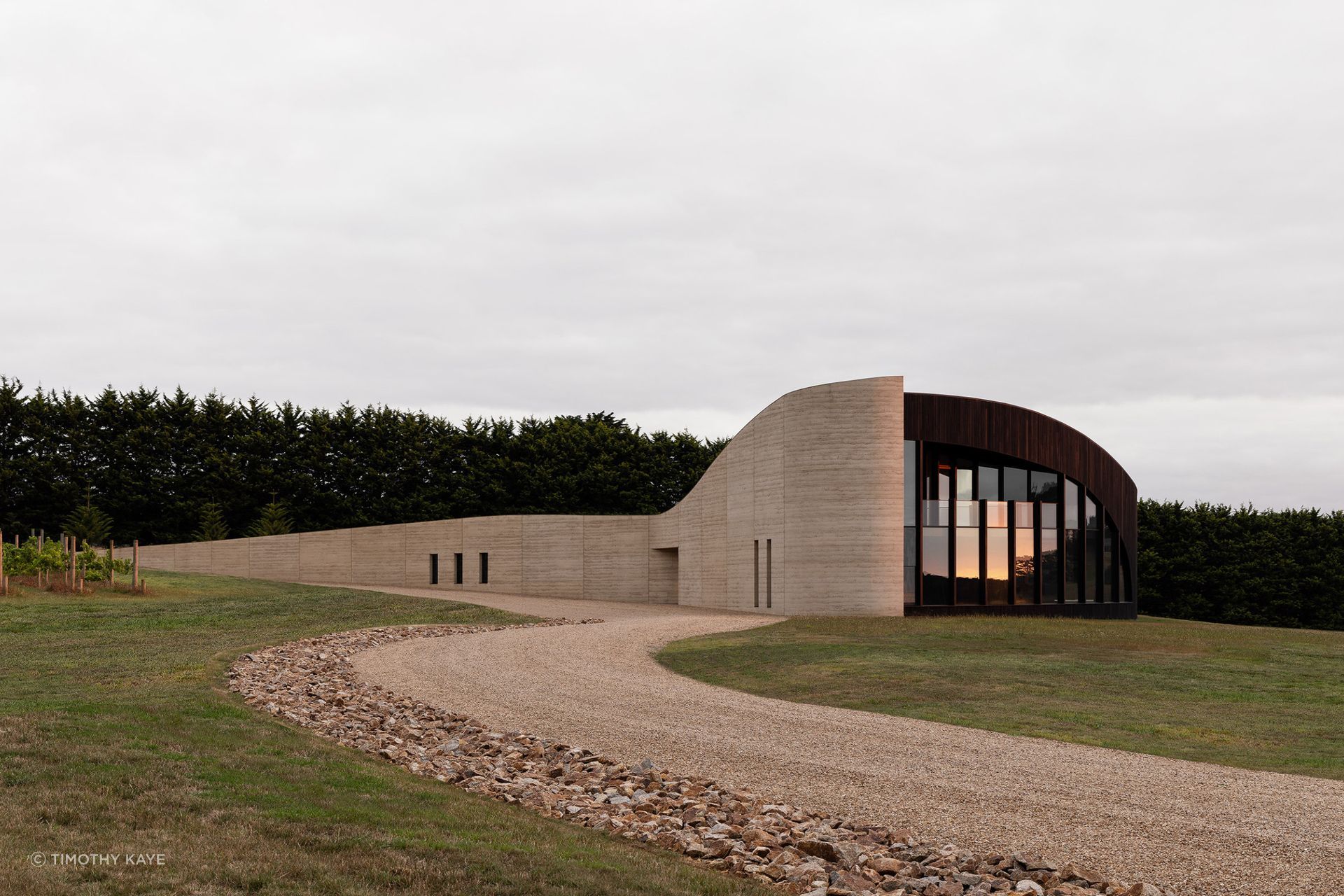 Peninsula House by Wood Marsh emerges quietly from the terrain, its layered rammed earth capturing the colours and character of the peninsula landscape | Photography by Timothy Kaye