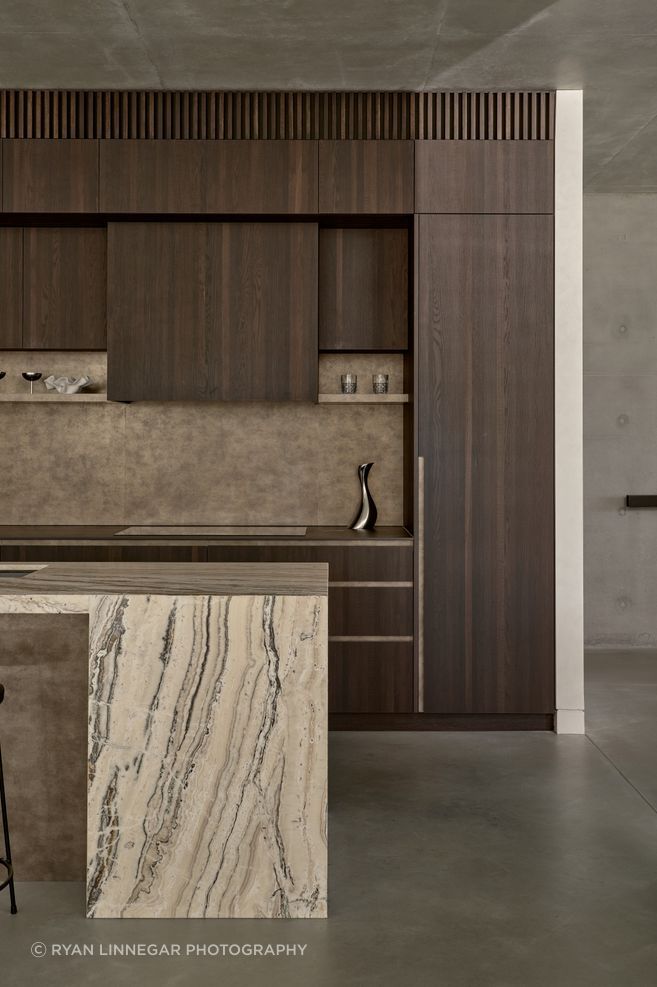 A restrained material palette of stone, timber and concrete creates a calm, grounded interior.