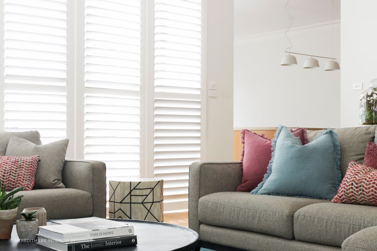 Red cushions can be infused with other bright tones for a sophisticated colour palette. Featured project: Ashburton House.