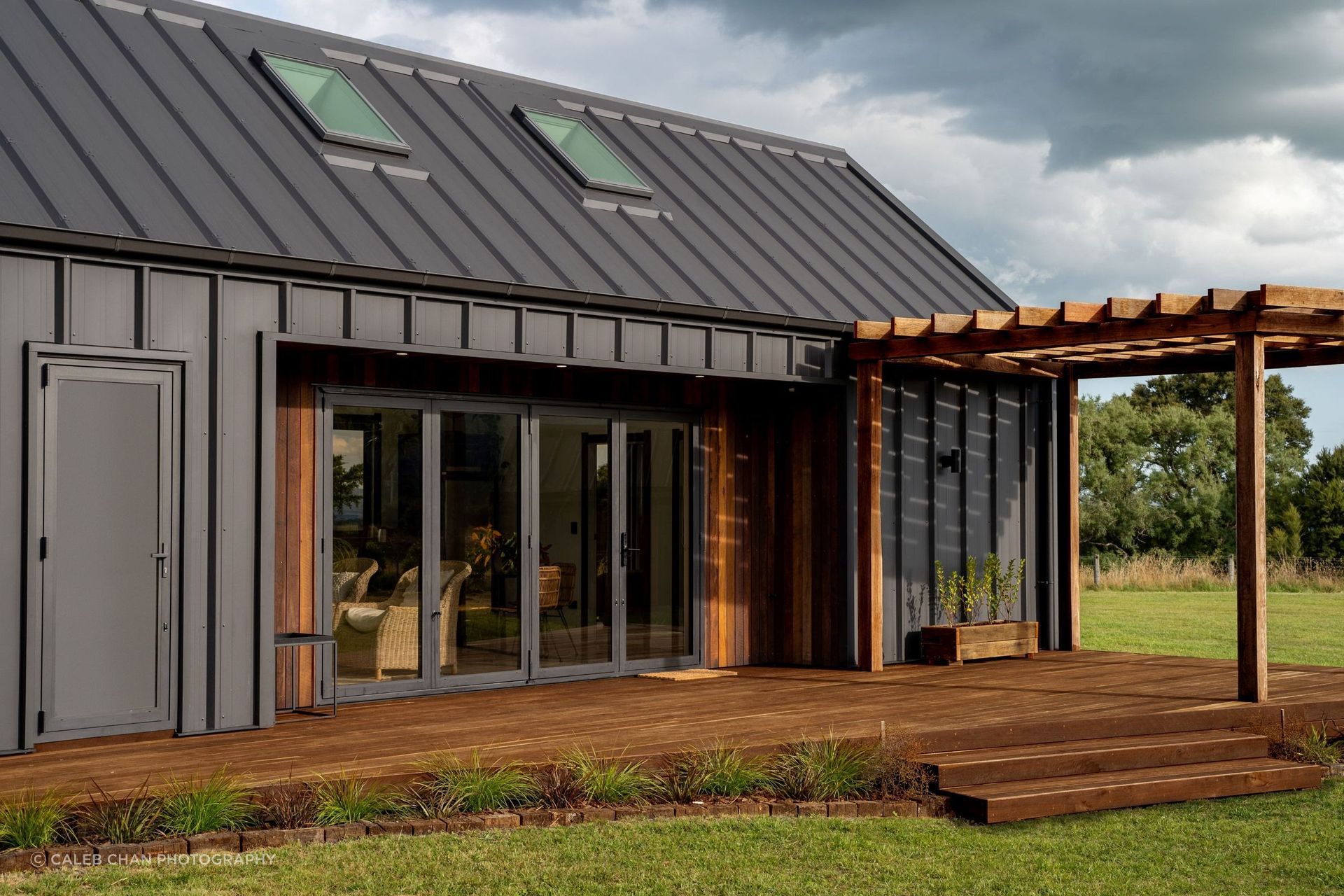 Kāhu Cottage features a beautiful deck with a pergola made of reclaimed hardwood. | Photography: Caleb Chan Photography