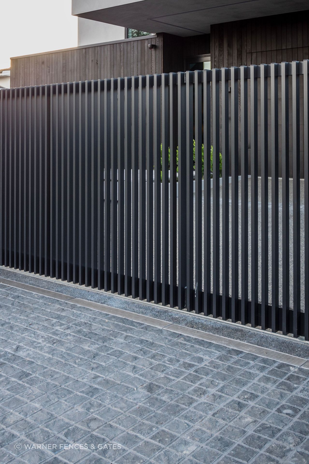 The sliding drive gate is automated and equipped with safety beams.