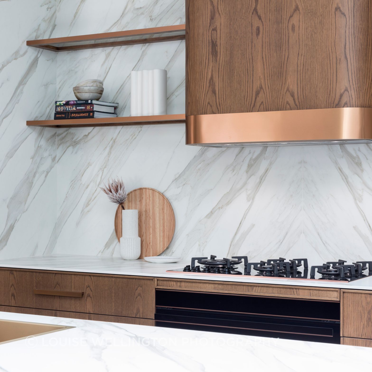 Oxford Project.   Front of House kitchen wall features Neolith clad walls and Farmers Doors curved rangehood box, bronze metallic trims.
