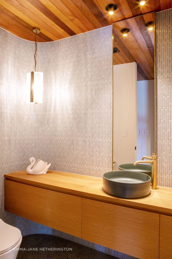 The powder room hidden in the foyer, echoing the curved motif outside the house.