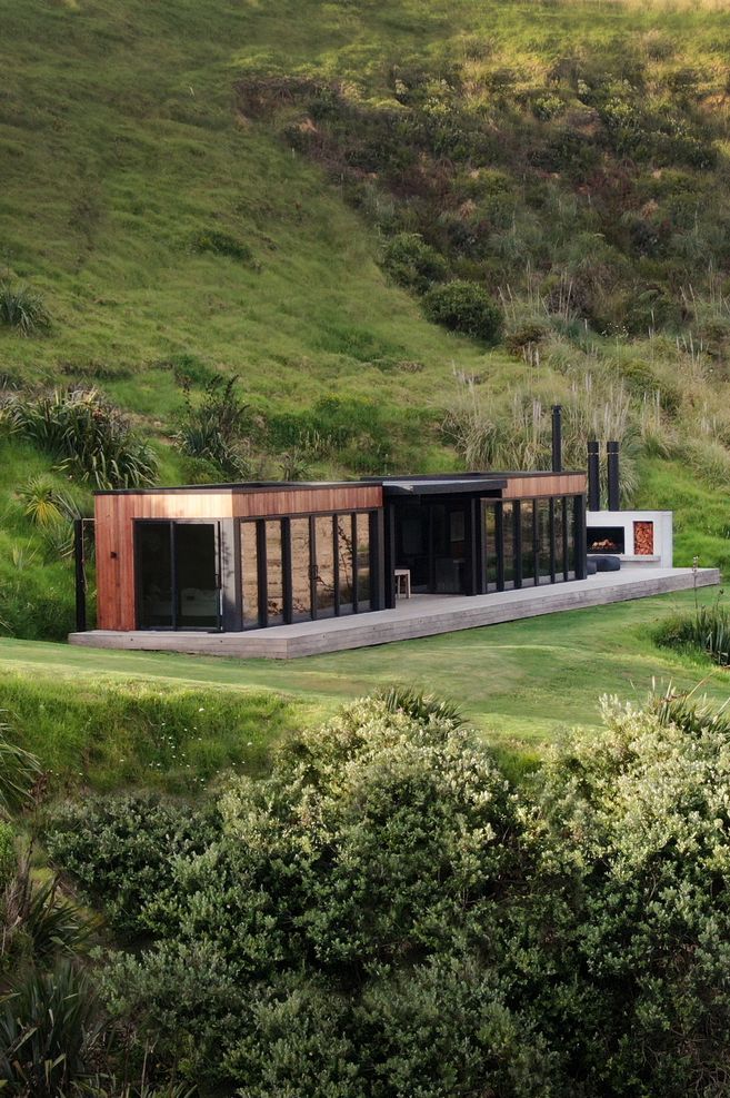 The simple home nestles into the landscape on Bridget's family farm on the Cavalli Coast.