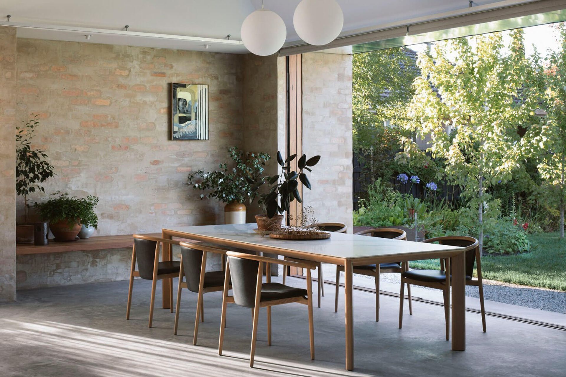 The Otway Armchair and Dining Table from the Kett living collection features warm timber tones and minimalist curvaceous forms.