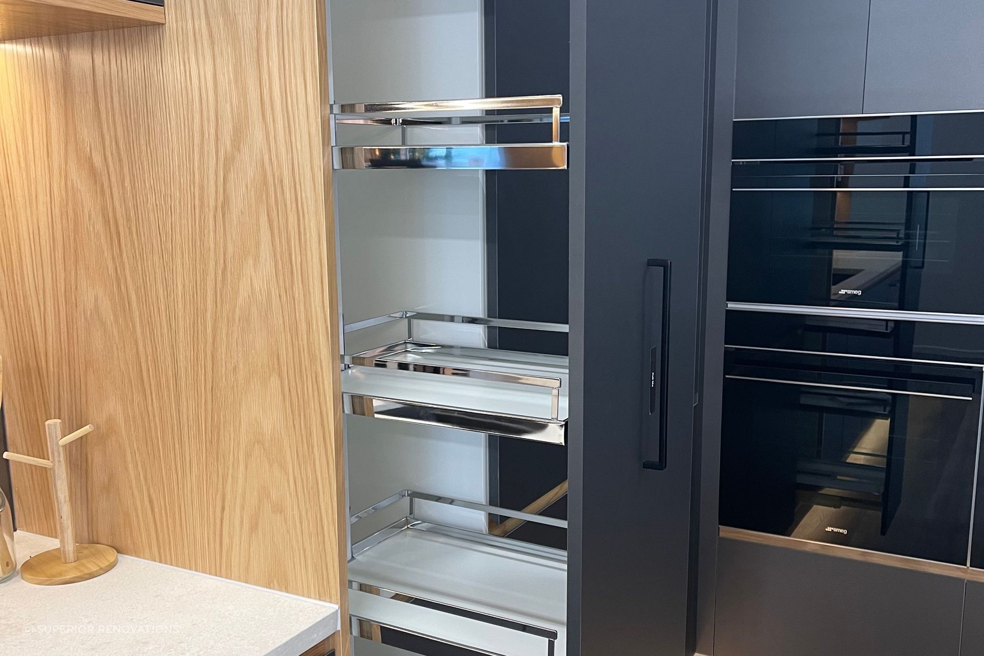 Pull out pantry with in-built shelves makes it easy for you to clearly see all the stored items and retrieve them. – This pantry can be seen in our matte black kitchen display in our Kitchen showroom in Auckland.