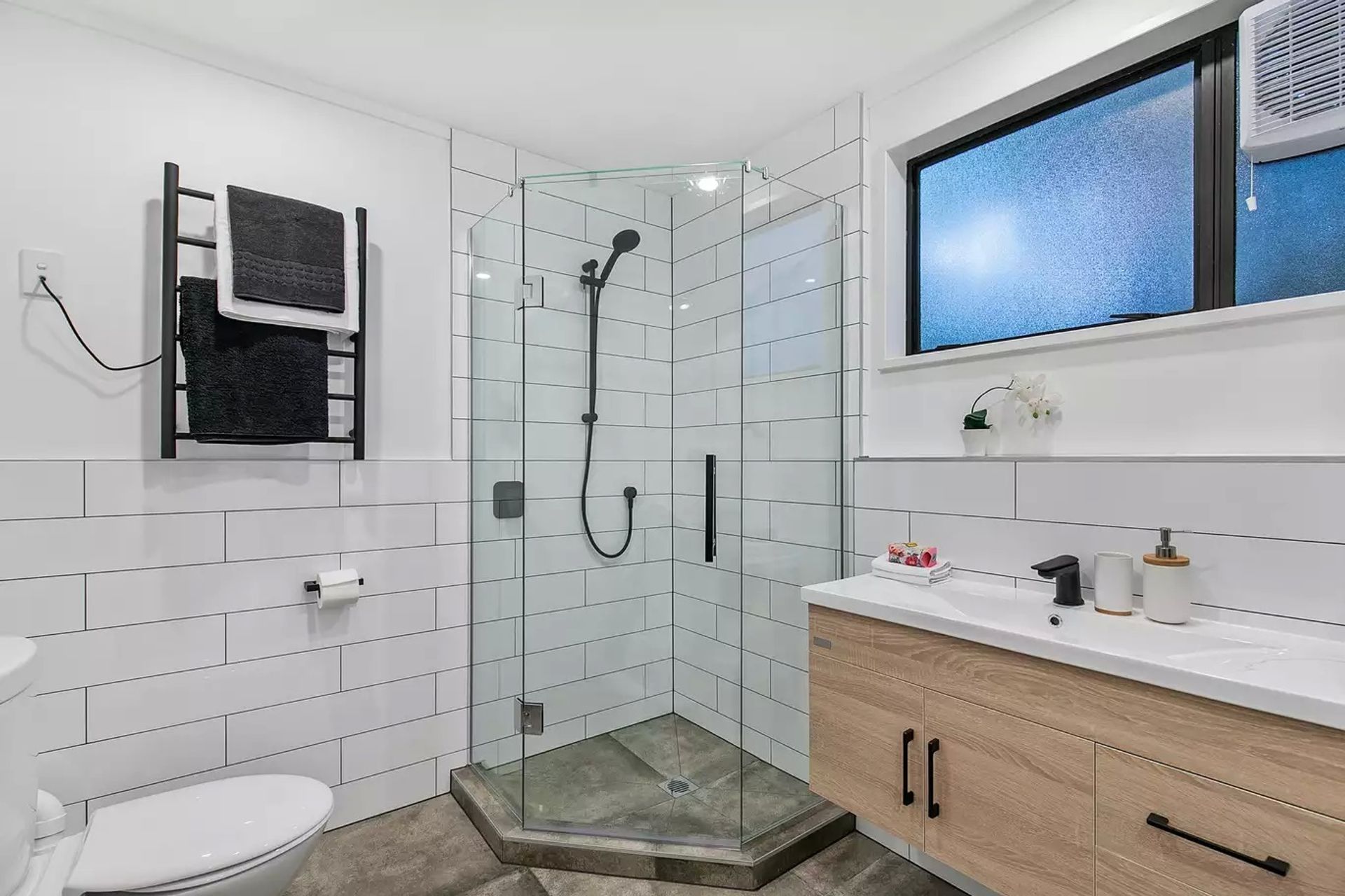  A small L shaped corner glass tiled shower