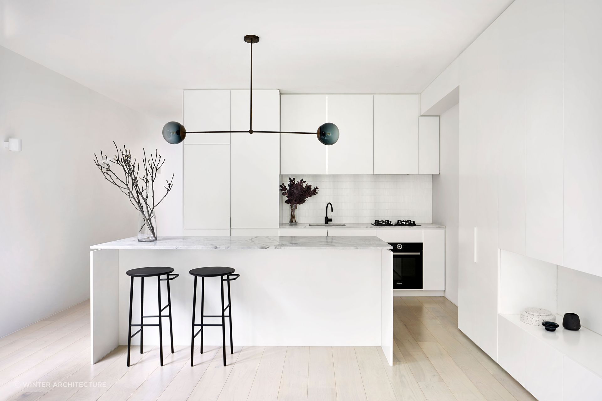 The kitchen embodies a sleek and minimalist aesthetic. Photography by Tatjana Plitt.