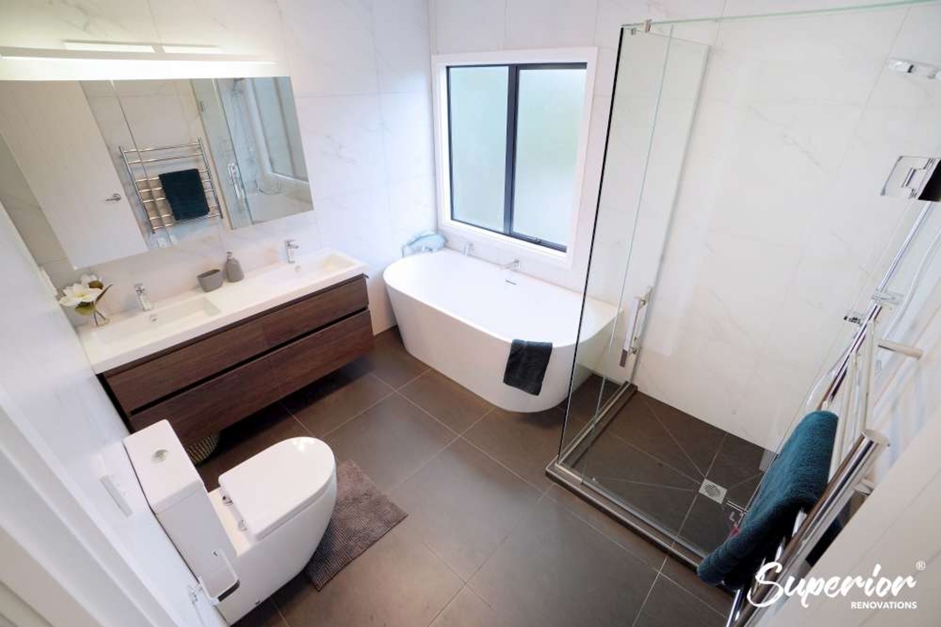 Dark brown 600 by 600 tiles were installed on the floors whereas white 600 by 600 tiles were installed on the walls to make the bathroom look spacious as well as create some drama