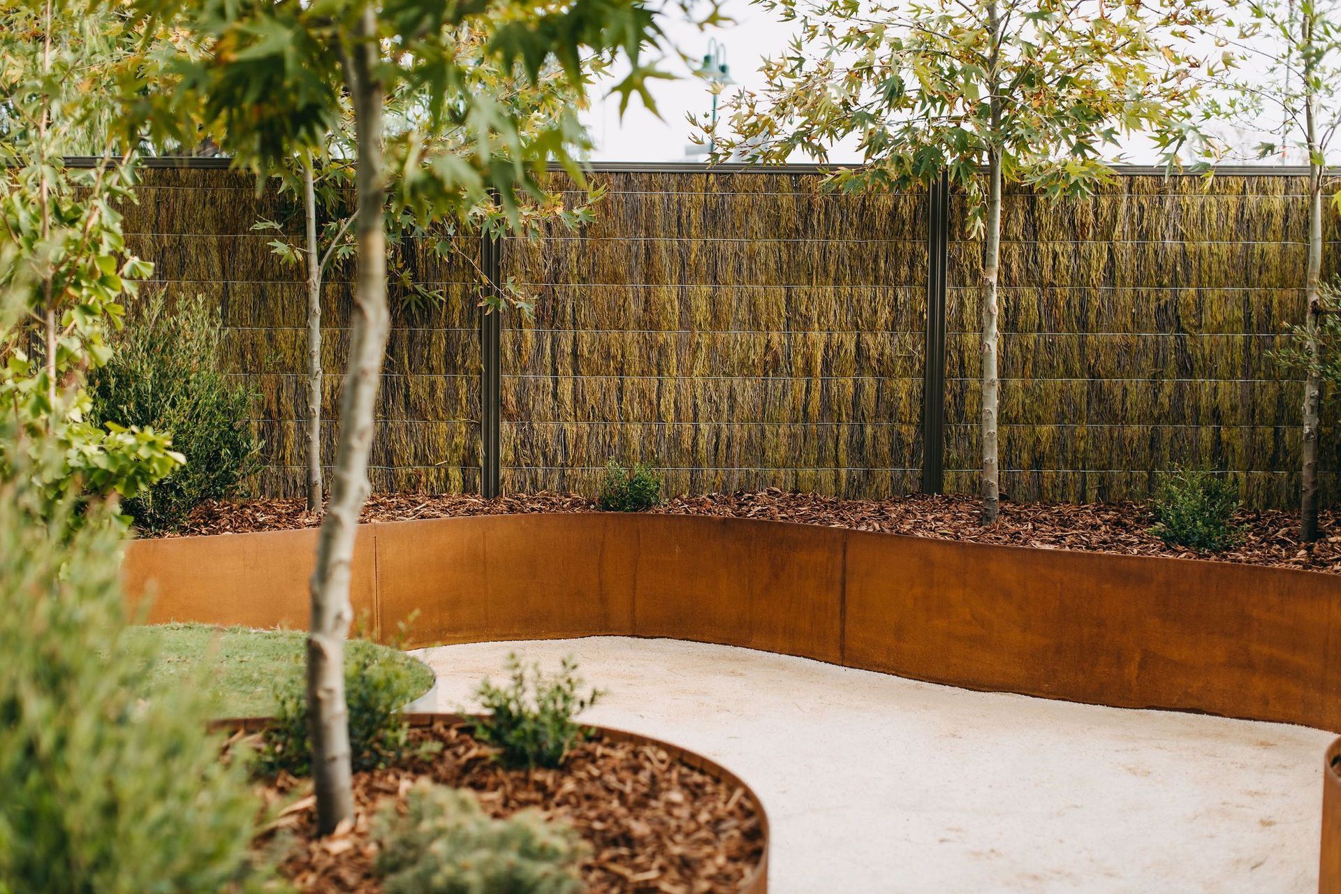 Straightcurve's range of flexible garden edging, retaining walls and modular planters—available in weathering steel and galvanised steel—has made it possible to create self-bracing, free-form curved garden beds.