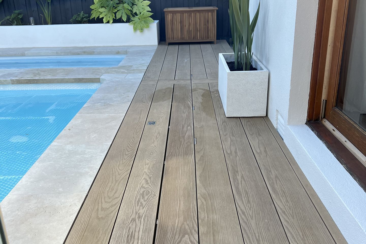 This timber decking pool cover is so seamless, it's practically invisible.