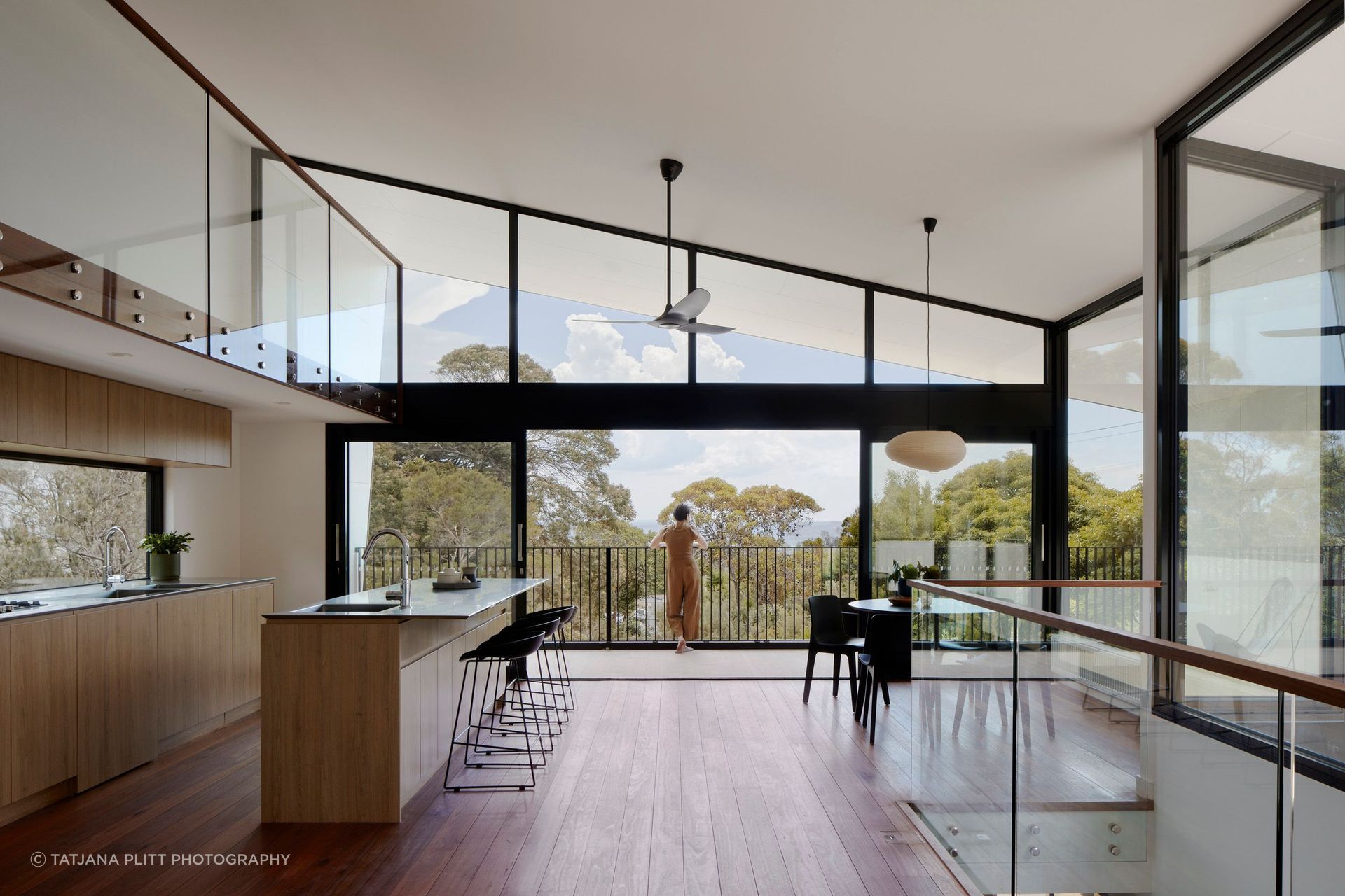 Floor-to-ceiling glazing captures the outlook across the bush landscape and out to the water.