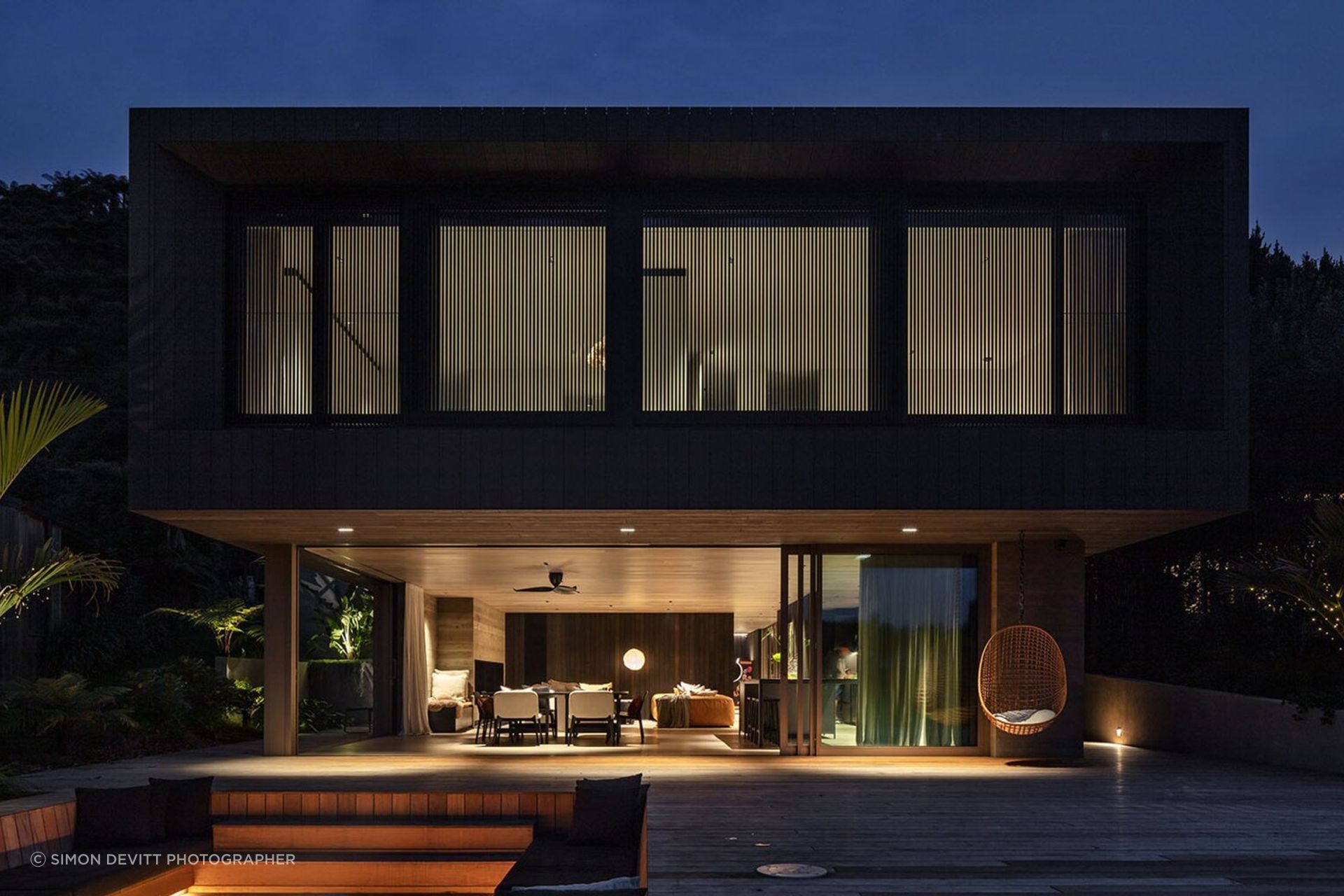 Sam and Fiona Fillmore’s lakehouse on the edge of Lake Rotoiti was designed by Evelyn McNamara of Evelyn McNamara Architecture. The ground-level glass doors open completely to welcome and provide a connection to Sam’s childhood bach next door.