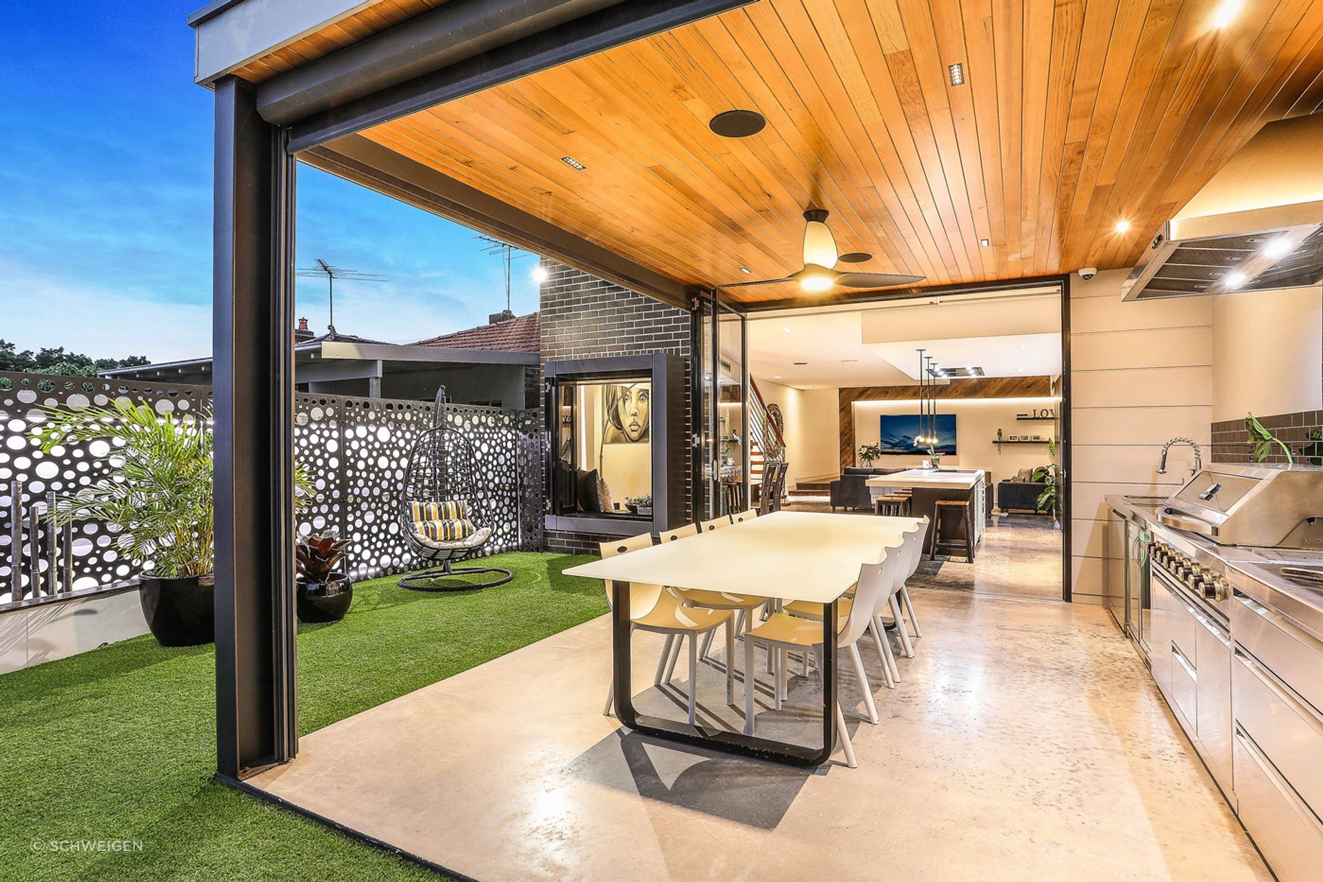 A very well lit outdoor kitchen in a modern home in Sydney with plenty of task lighting in and around the dining and grilling area