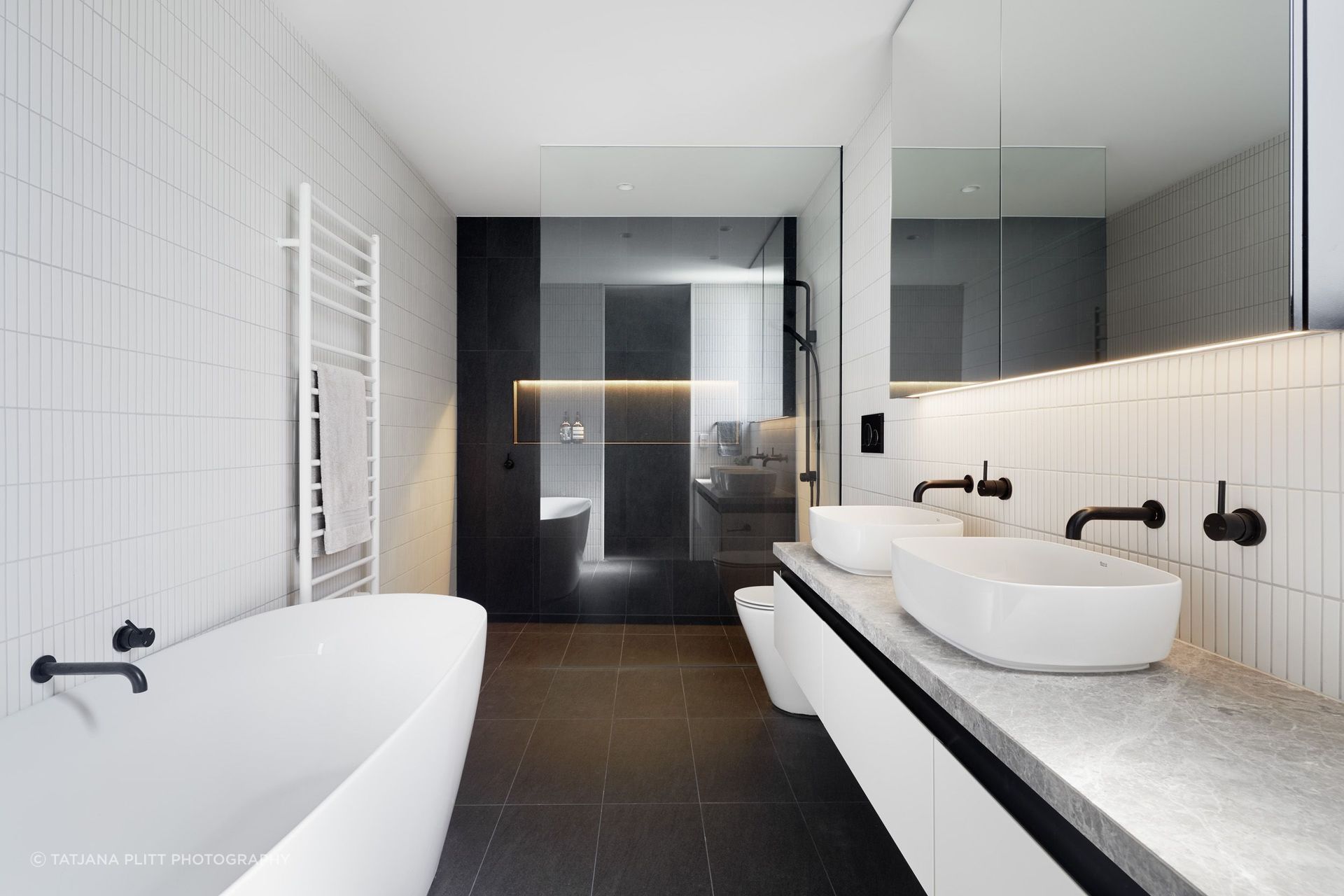 White finger tiles and black tapware feature in the master ensuite.