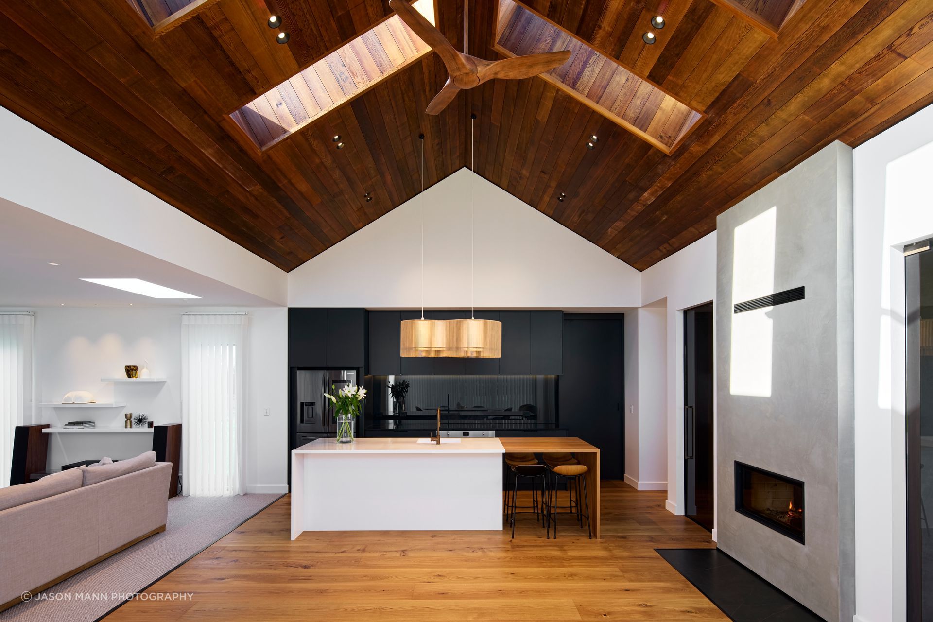 Cedar lines the ceiling, with hardwood American oak flooring a contrast to the sleek, dark kitchen cabinetry.