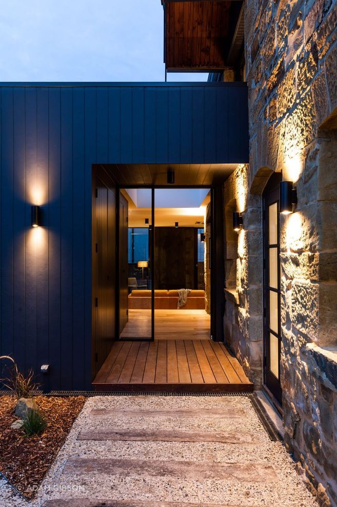 The addition transitions and flows into the sandstone volume without a marked division between heritage and contemporary.