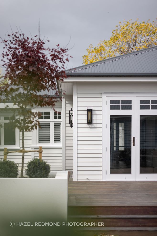 The open-plan living area connects to the deck and backyard through glazed doors.