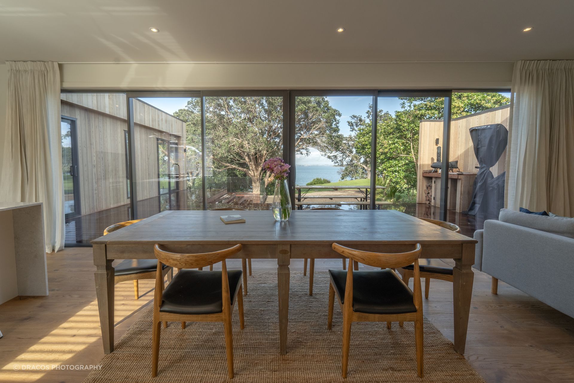 The open-plan living area looks out over the cliff’s edge to the shimmering Waiheke coastline.