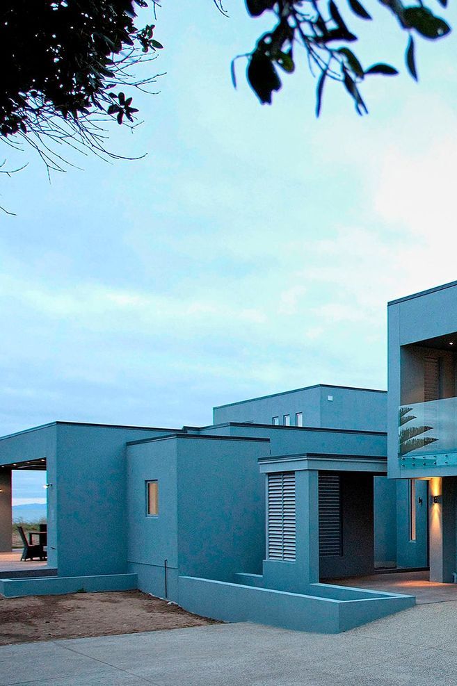 Soft eggshell blue blends this Orewa home into the sky and seascape.