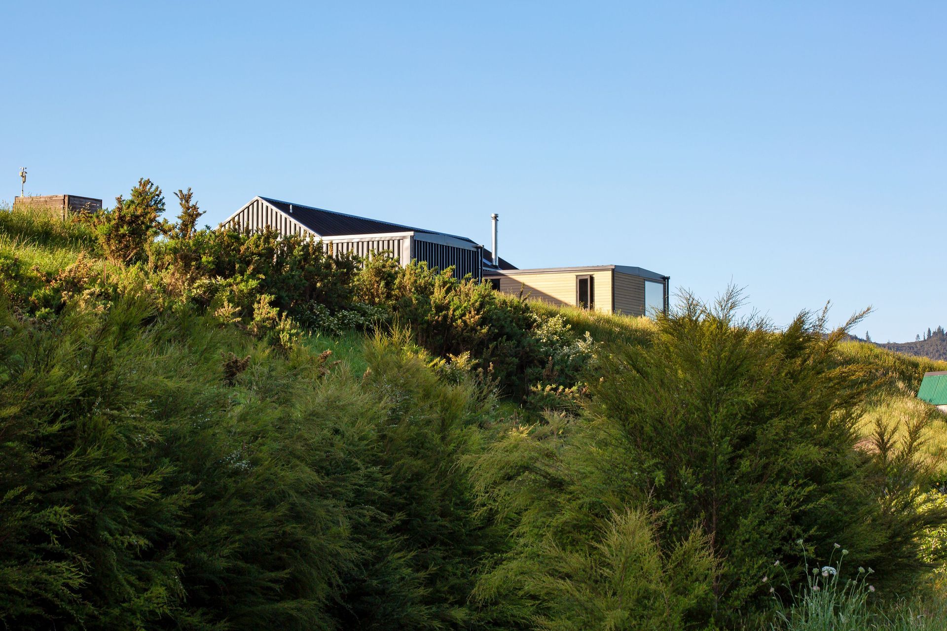 Perched on a knoll overlooking sleepy farmland and an alluvial valley, the site looks out to The Pinnacles and to the Tairua River.