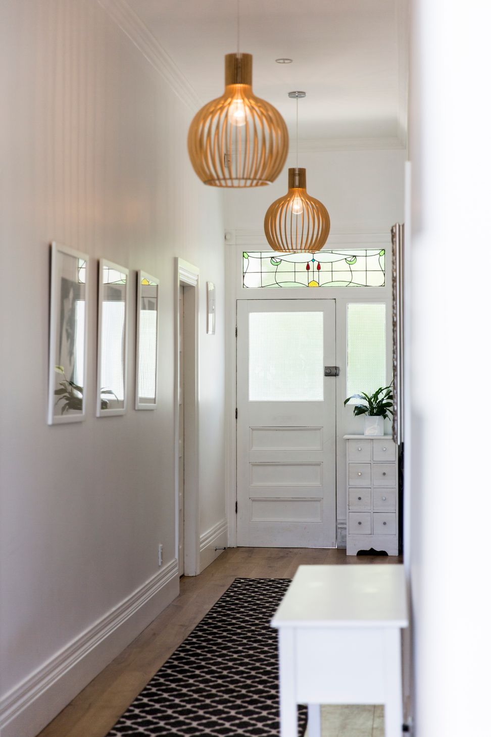 The original hallway at Grey Lynn Villa — stained glass fanlight intact, timber pendant lights and heritage detailing preserved while the rest of the home was reimagined behind it. Macfie Architecture.