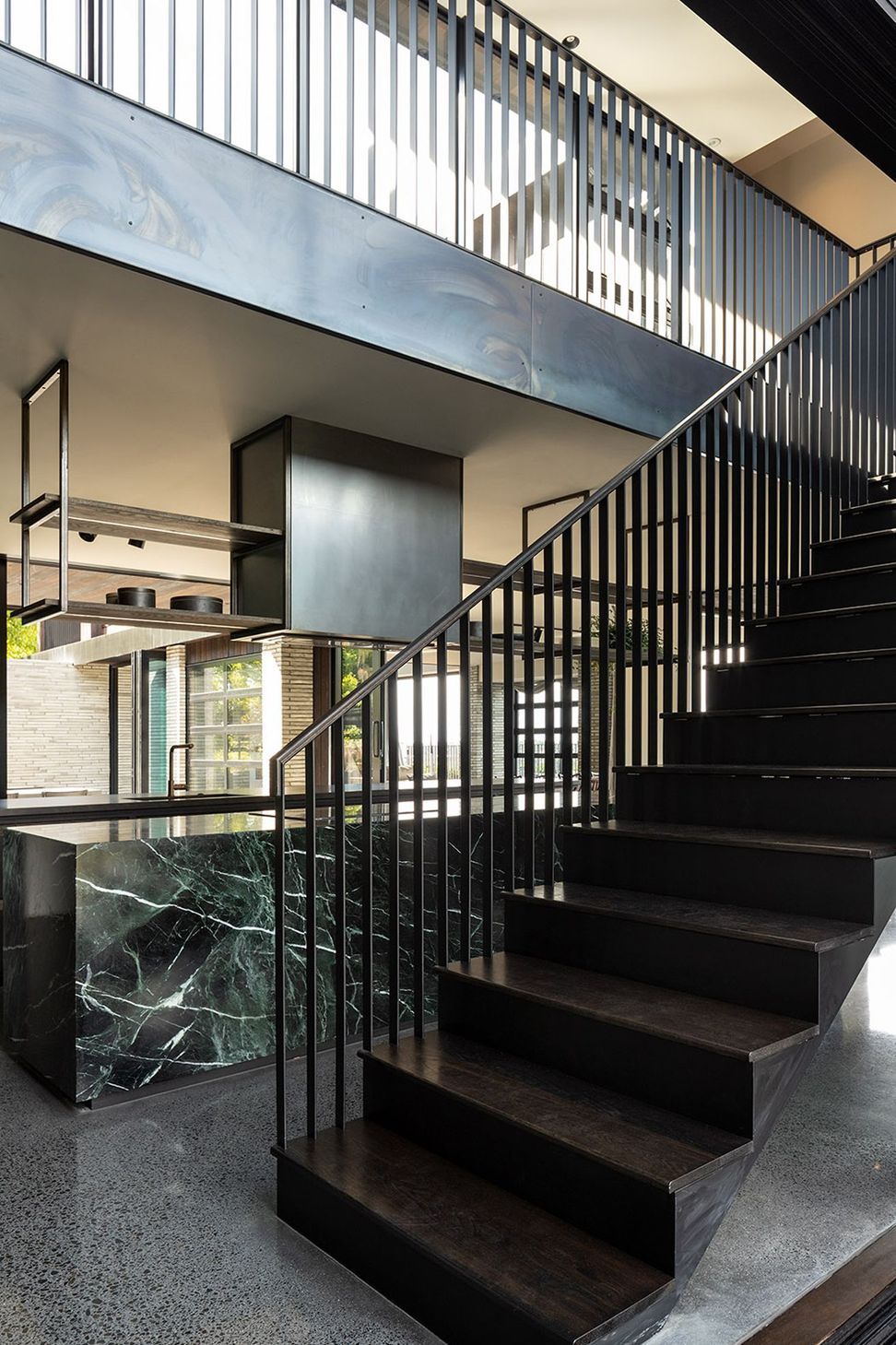 A striking steel balustrade leads to the upper pavilion that houses the private areas of the house.