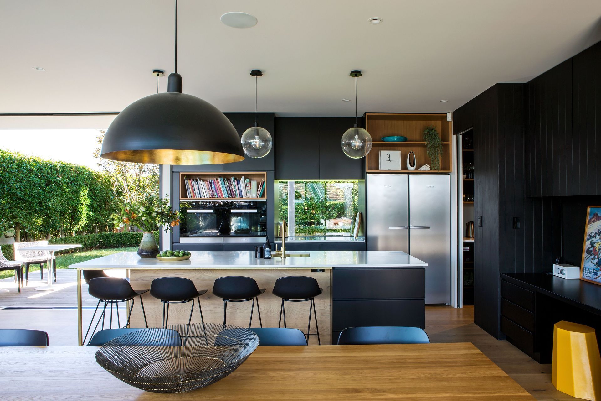 Unusually, a window has been placed behind the cooktop, replacing the kitchen splashback with an animated framed view of the garden.