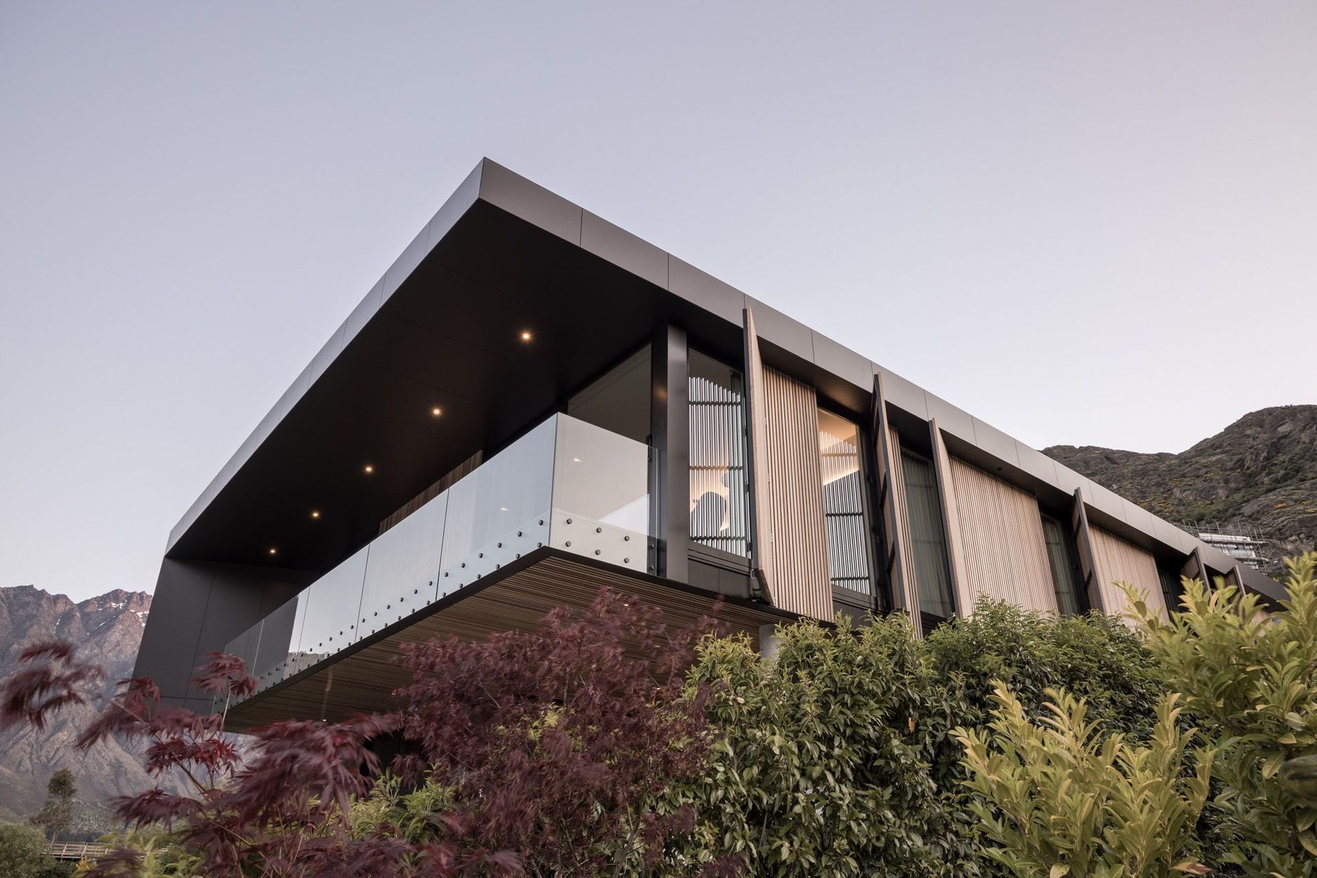 A ‘big box over a little box’ concept has created a cedar box that flies out over an outdoor room, with activated cedar screens on the side to create privacy from the neighbouring hotel.