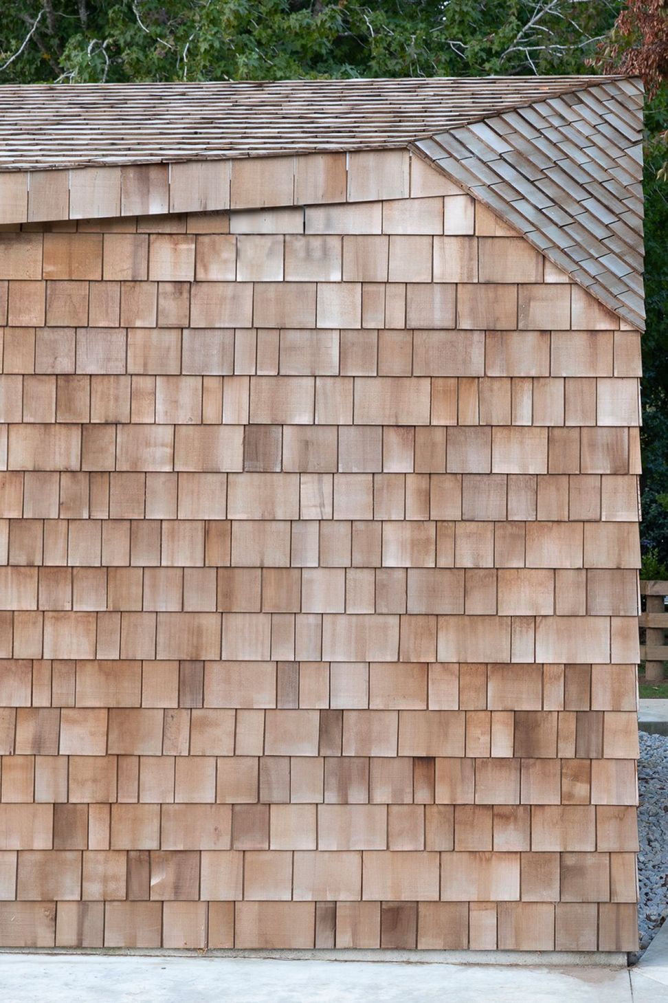 Cedar shingles add texture and warmth to the sharp sculptural form of the garage.