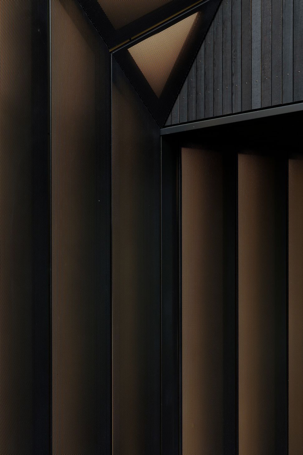 Perforated metal screens adopt the metaphor of a shirt cuff to define the entry. 