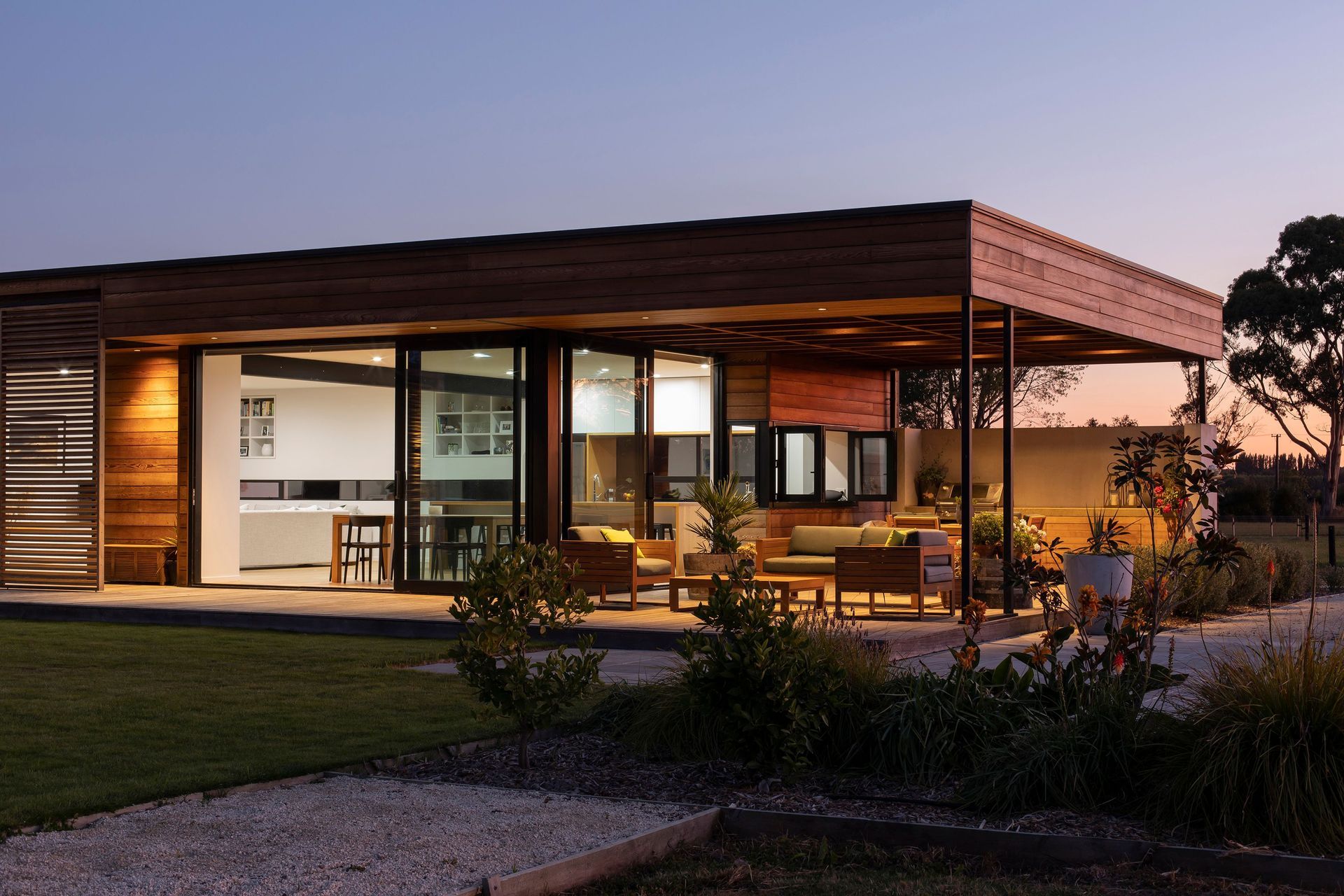 The outdoor room faces north and northwest and leads into the open-plan kitchen, dining and lounge areas. At the rear of the outdoor room is a built-in BBQ and outdoor dining table.