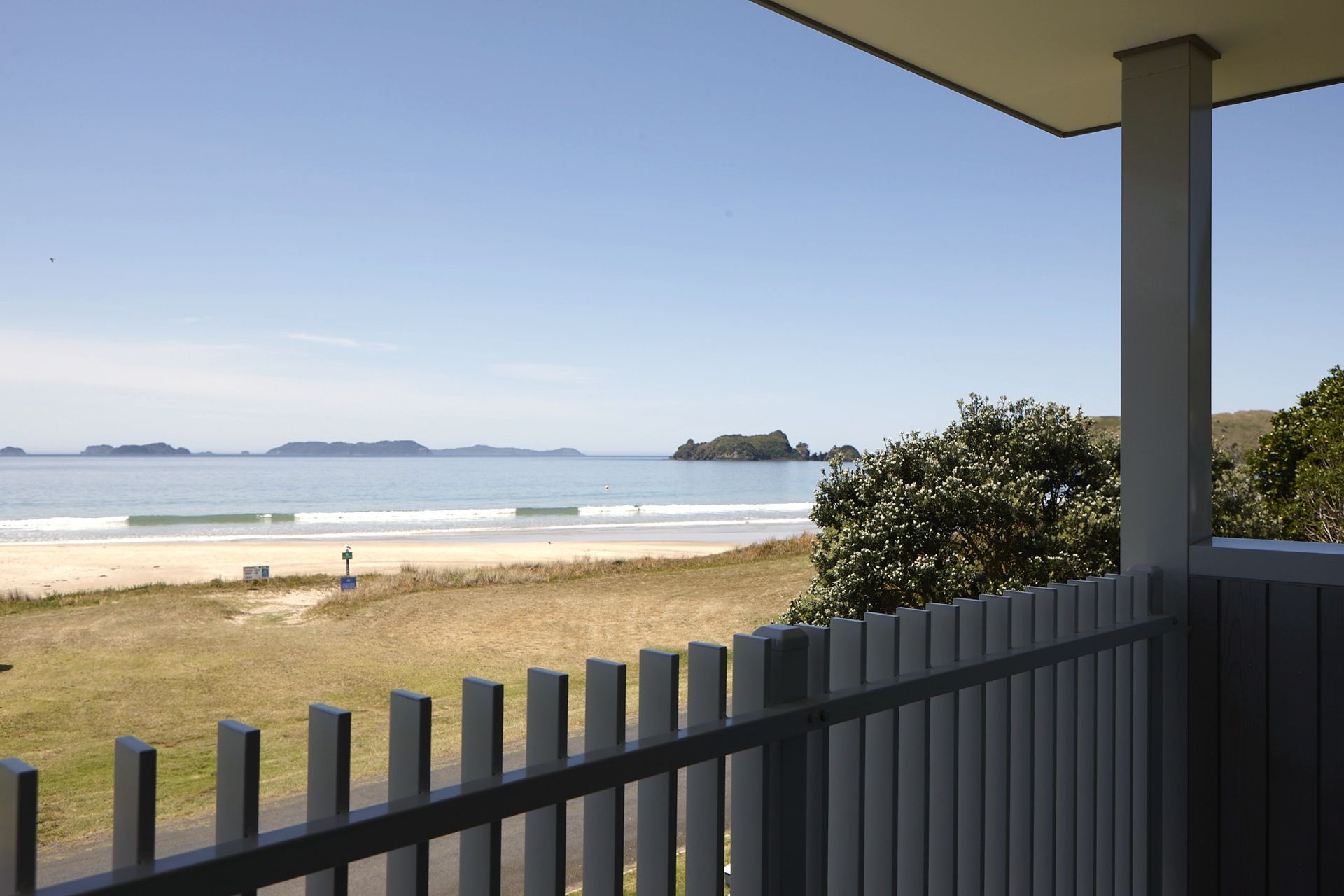 From the front deck, expansive views stretch across the beach and the waters of Opito Bay. The elevated outdoor living area provides a sheltered place to enjoy the changing coastal landscape throughout the day.