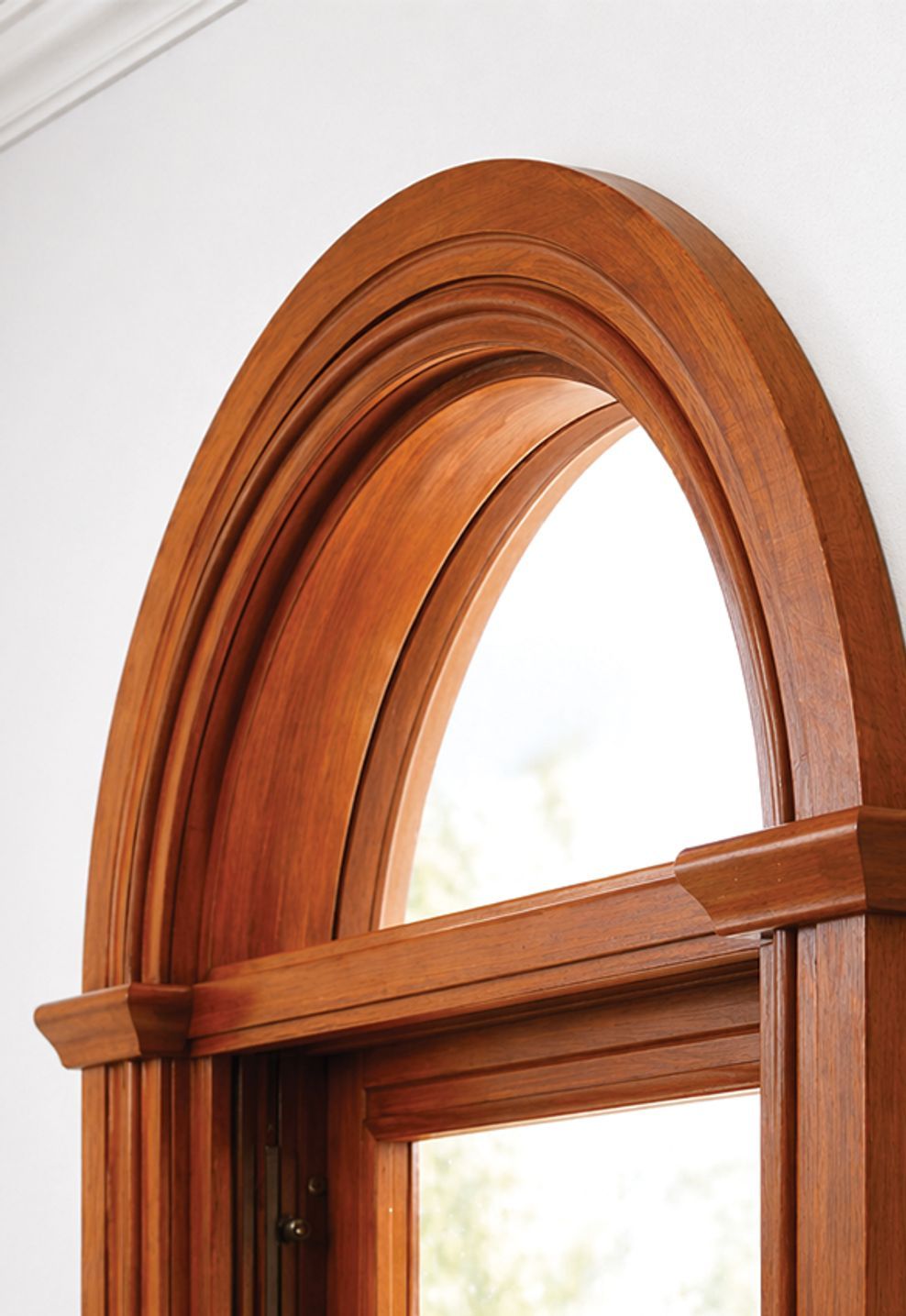 Custom curved timber architrave framing an arched window, showcasing seamless profile continuity and precision-crafted detailing for high-end architectural applications.