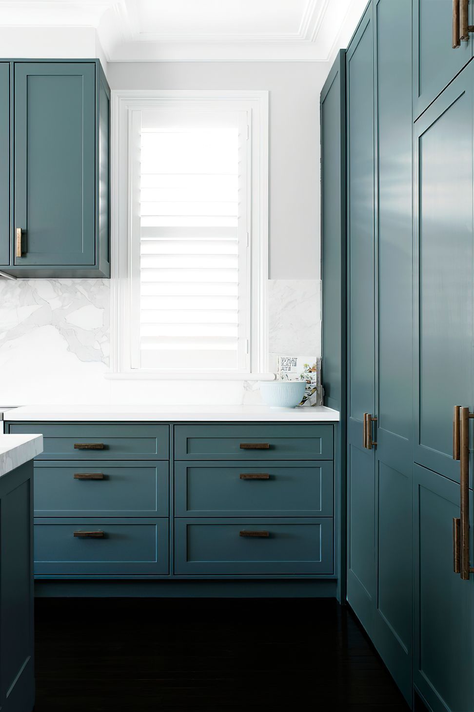 KITCHEN STORAGE - Loads of storage and extra benchspace were created in this kitchen renovation. Natural light pours through the shuttered windows.