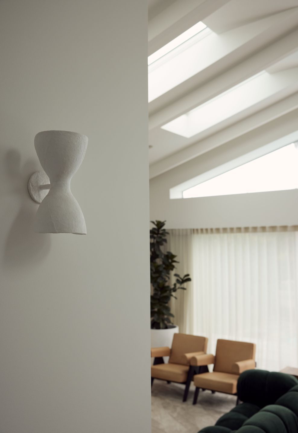 The Anna Charlesworth Hourglass wall light in the rear addition at Point Chevalier Bungalow. In collaboration with Hannah Warren Interiors.
