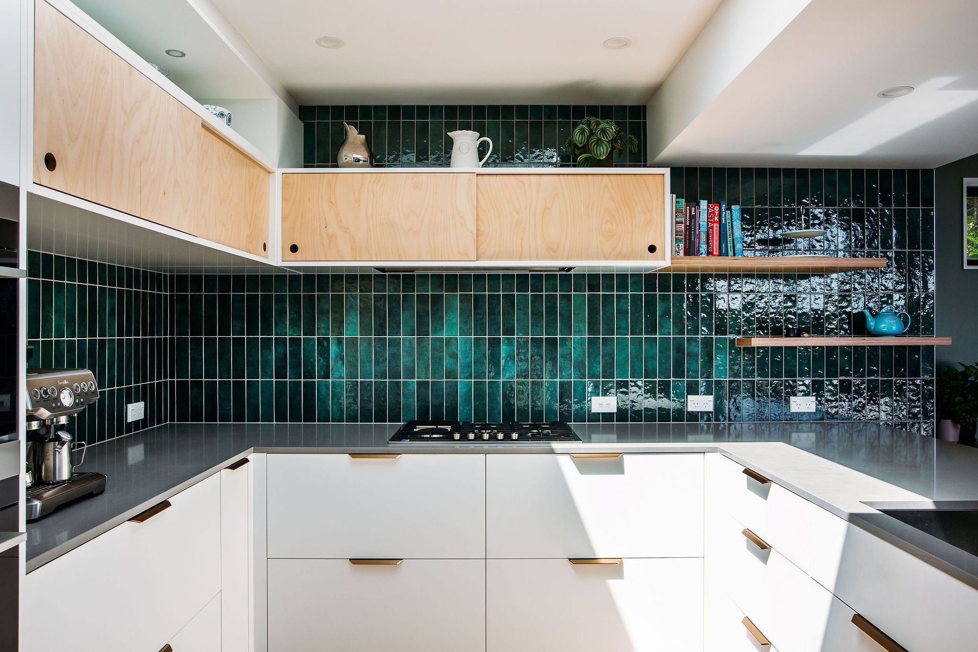 Simple plywood sliding cabinets above, brass pull handles below.