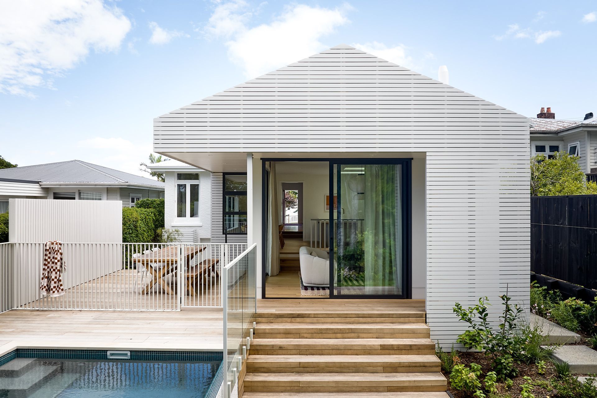 Viewed from the garden, the contemporary rear extension clearly references the proportions of the original bungalow. The carefully composed roofline allows the modern addition to sit comfortably alongside the heritage home.