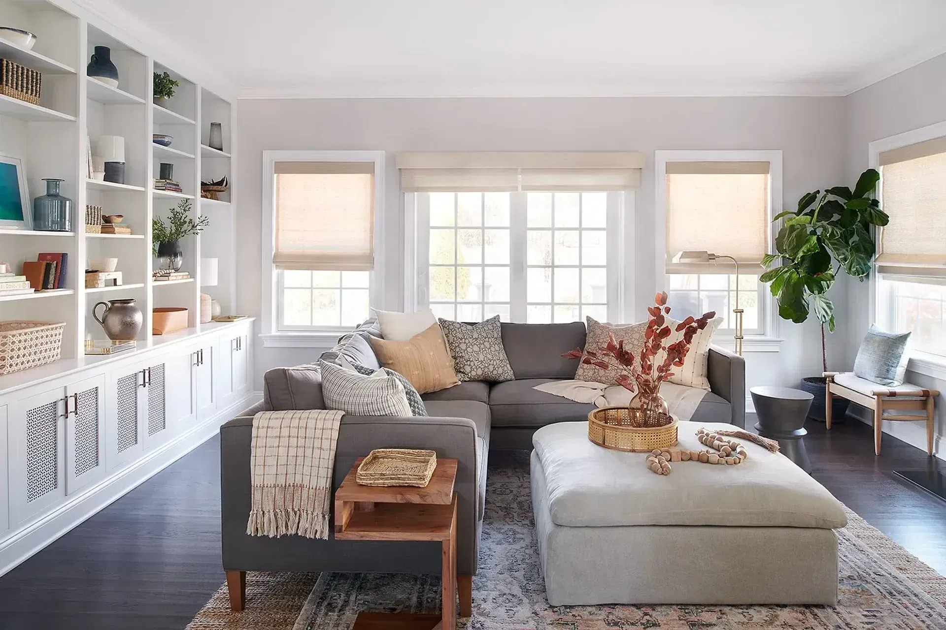 family-room-gray-sectional-tonal-ottoman-custom-Roman-shades-built-in-bookcases-Philadelphia-PA-Mainline.webp
