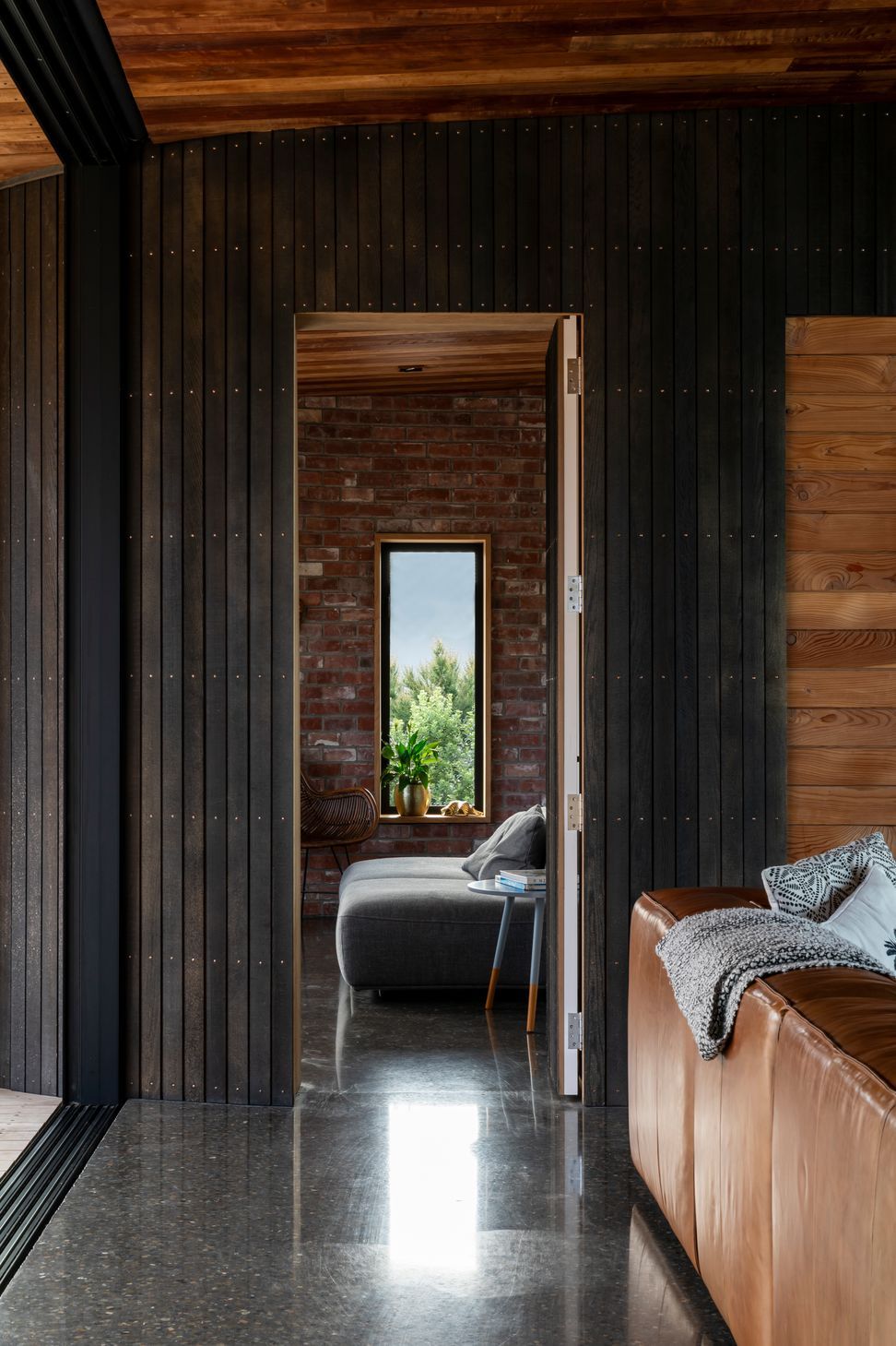 A wall and door paneled in a dark, stained cedar sit flush with each other when closed.