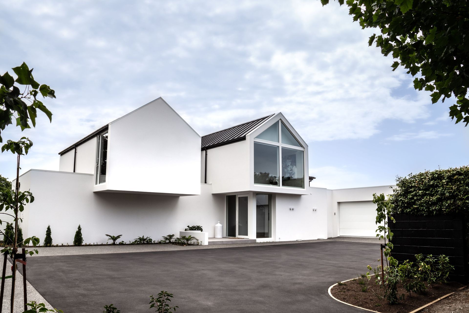 The entry courtyard with cantilevered gable forms and discreet entrance tucked underneath.