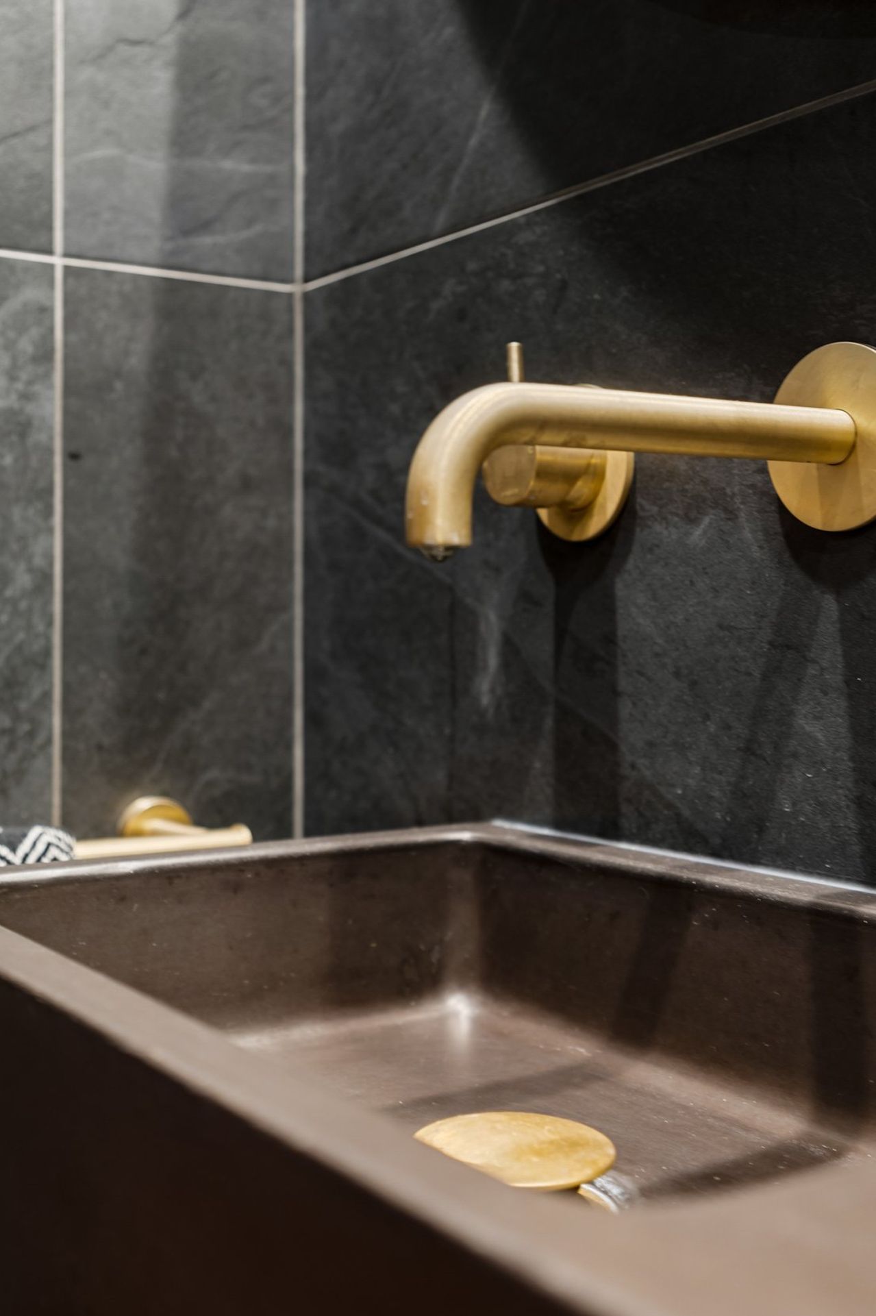 A thoughtfully curated combination features a striking Concrete Nation vanity, complemented by aged brass Progetto tapware and a stylish Missoni (Keith) hand towel, creating a perfect blend of modern design and timeless elegance.