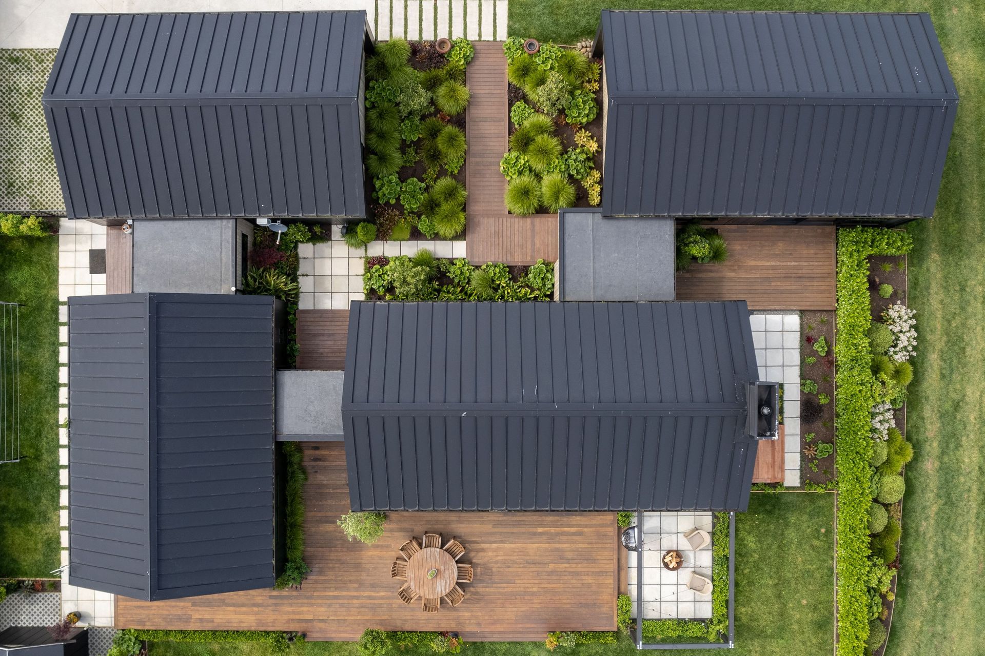 The modular layout creates several options for sheltered courtyards on all sides of the house connected by glazed walkways, bringing the outdoors in.
