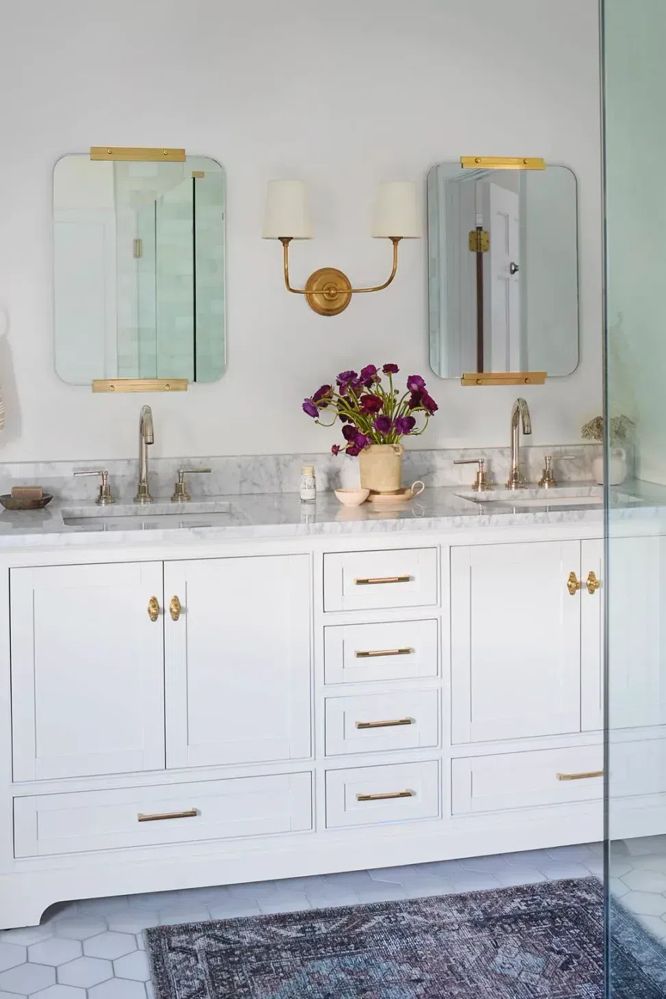 bathroom-renovation-white-double-vanity-bronze-hardware-bronze-sconces-marble-counter-top-marble-hexagon-tile-sharp-and-grey-interiors-philadelphia-pa.webp