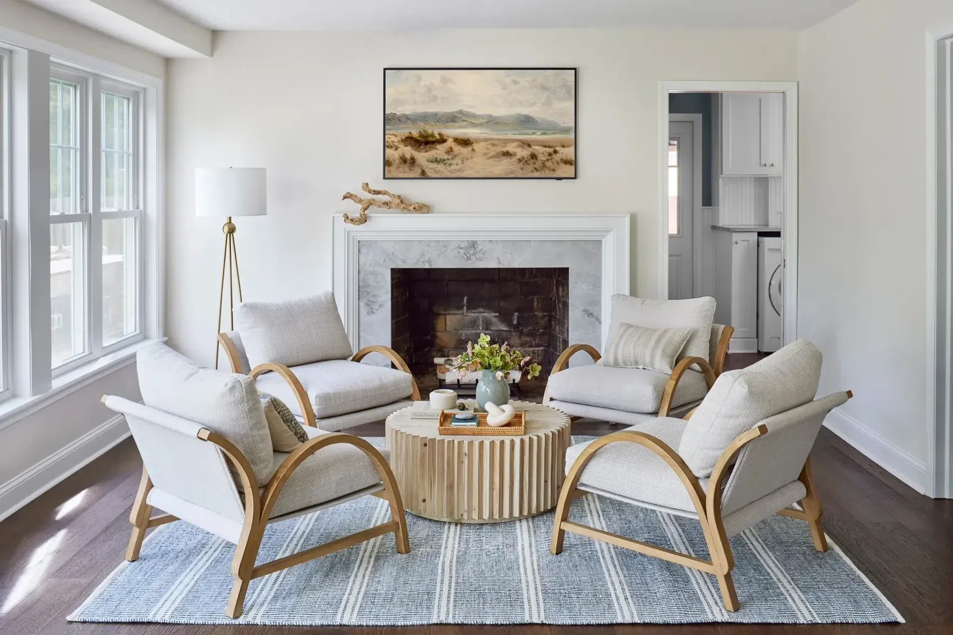 classic-modern-sitting-room-dark-hardwood-floor-stripe-rug-wood-fabric-accent-chair-marble-fireplace-sharp-and-grey-interiors-philadelphia-pa.webp