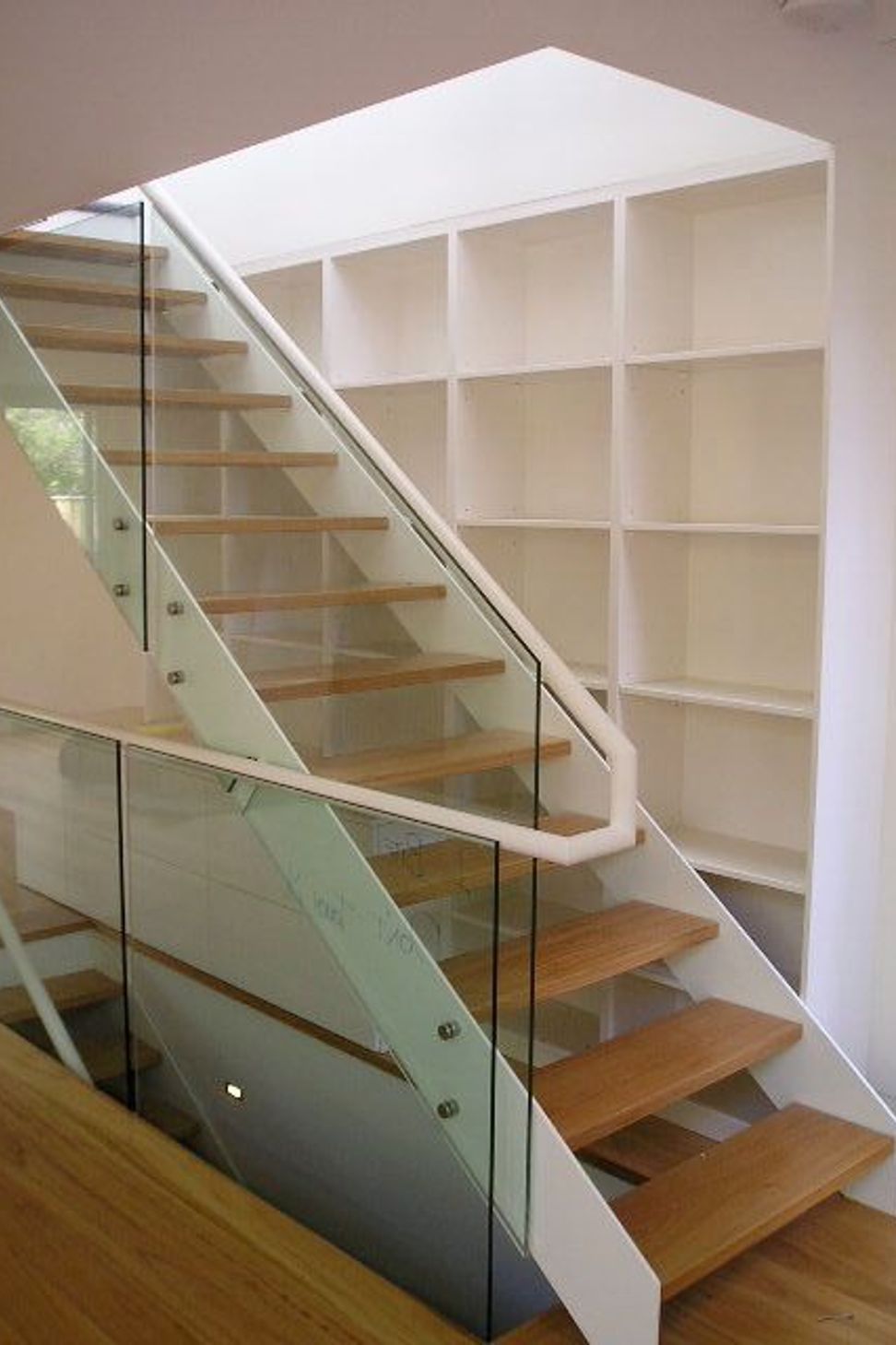 Timber, steel and glass feature stair with shelving behind