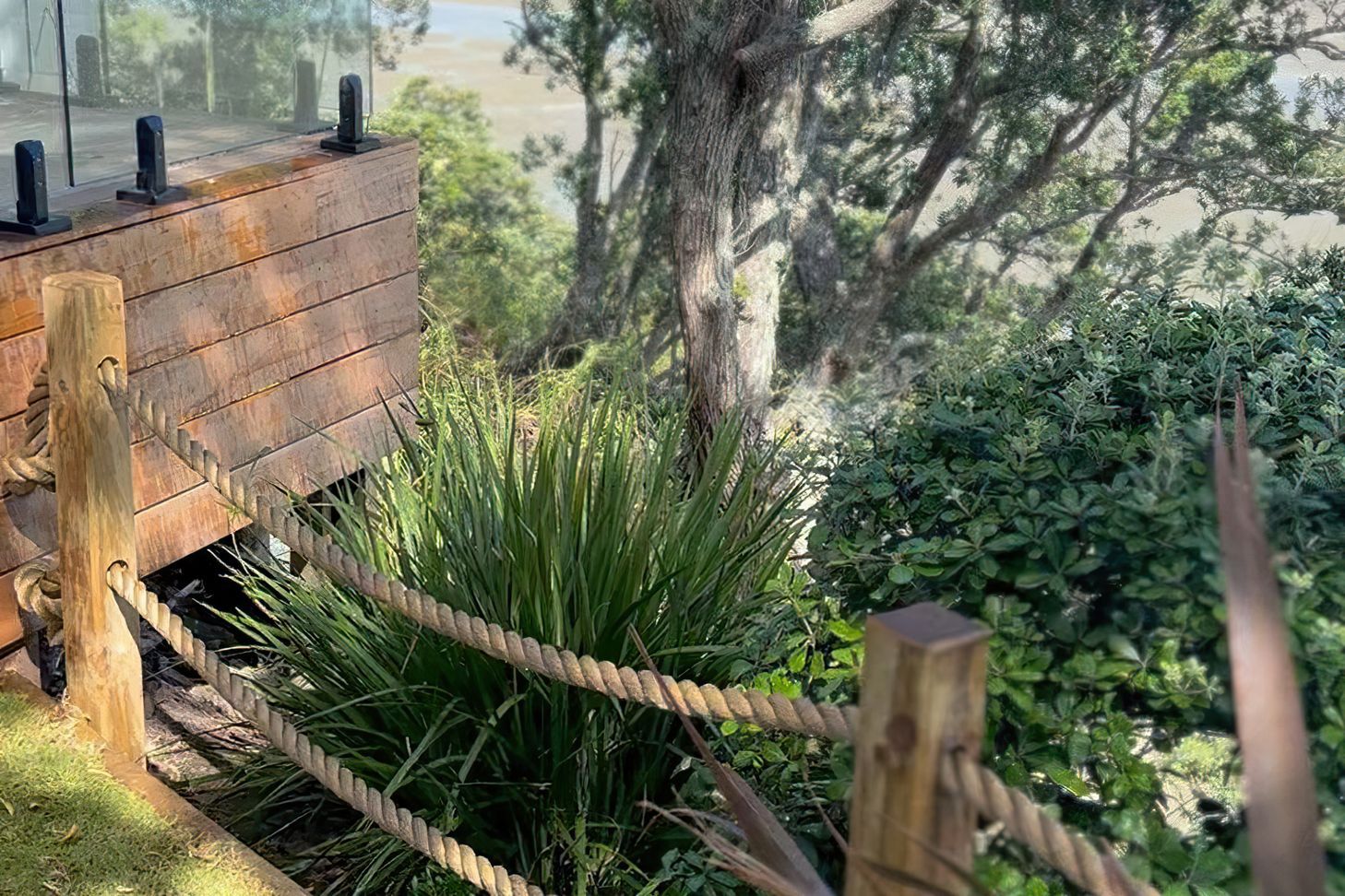 Custom rope fence with wood posts and heaps trees and bushes on the opposing side