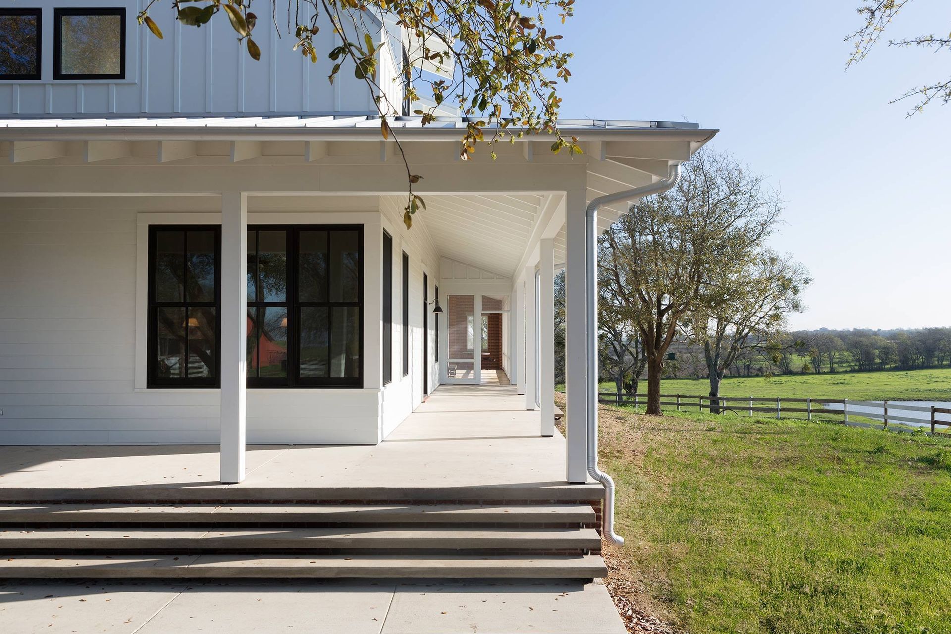 10PendletonFarmCuppettKilpatrickArchitectureandInteriorDesignaustin-tx-modern-farmhouse-long-porch-pastoral-view-1.jpg
