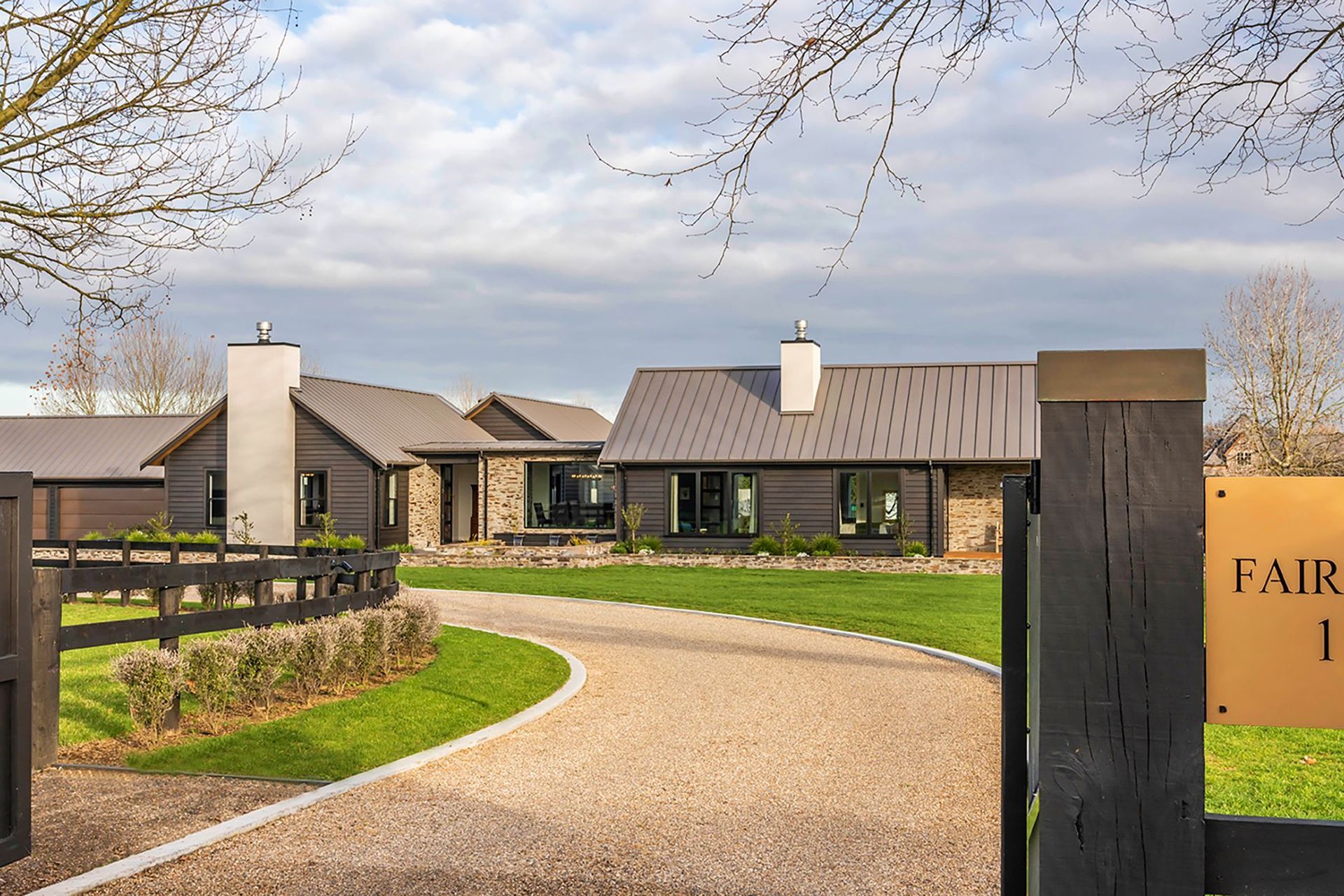 Set within idyllic Cambridge horse country, this rural home has a sophisticated lodge aesthetic with dark-stained cedar weatherboards and bagged stone to the exterior.
