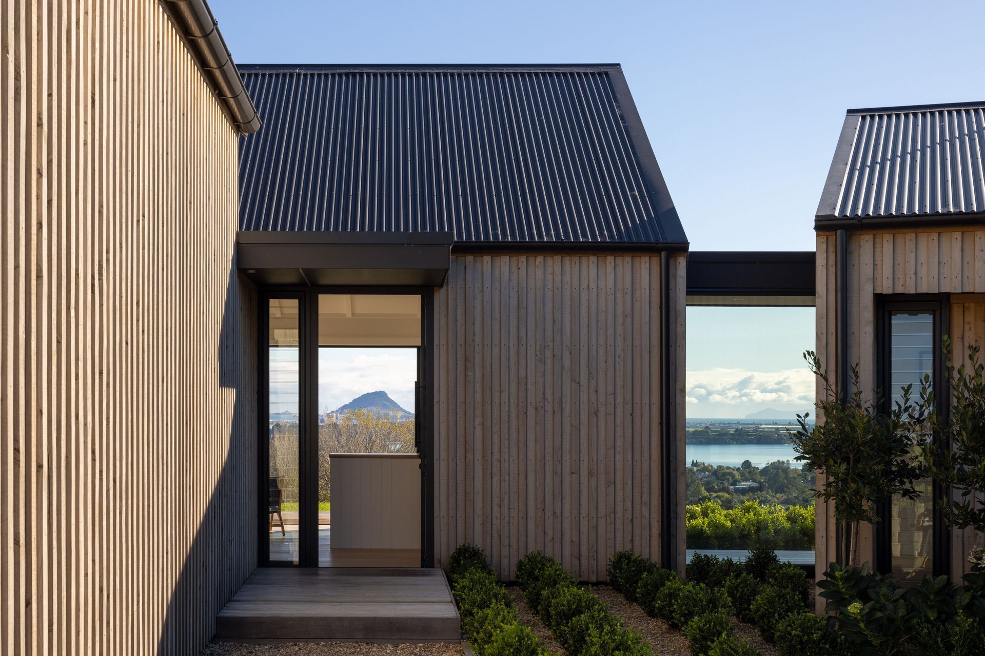 The unostentatious entry is accessed to the right of the garage and leads visitors directly into the living spaces; a glass atrium to the right of the entry enforces separation between  the living and bedroom spaces, while also offering visitors a sneak p